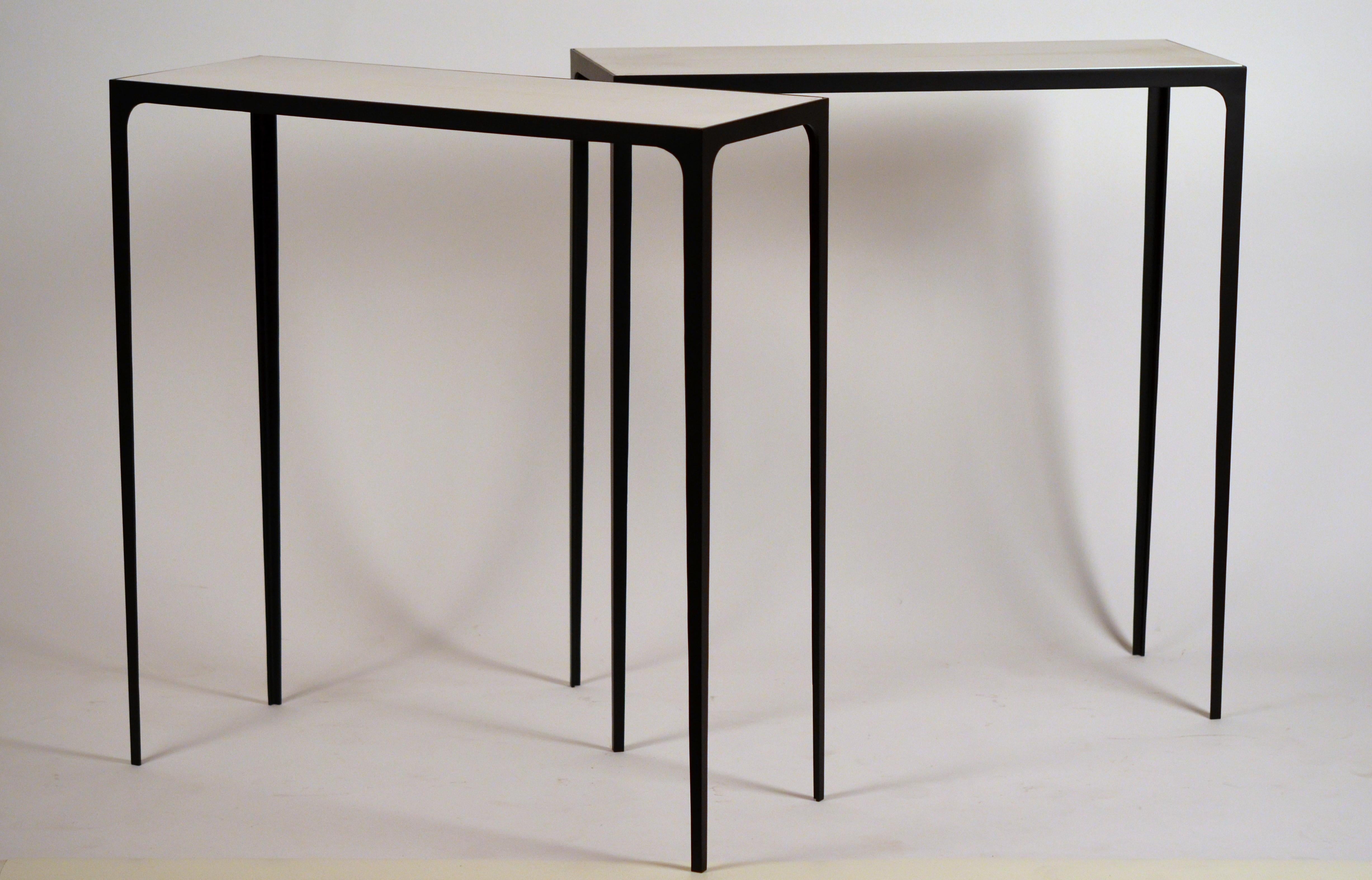 Pair of chic 'Esquisse' wrought iron and parchment consoles by Design Frères.

Contrasting white/cream goat parchment top over blackened slender steel base.

Beautifully simple, understated design.