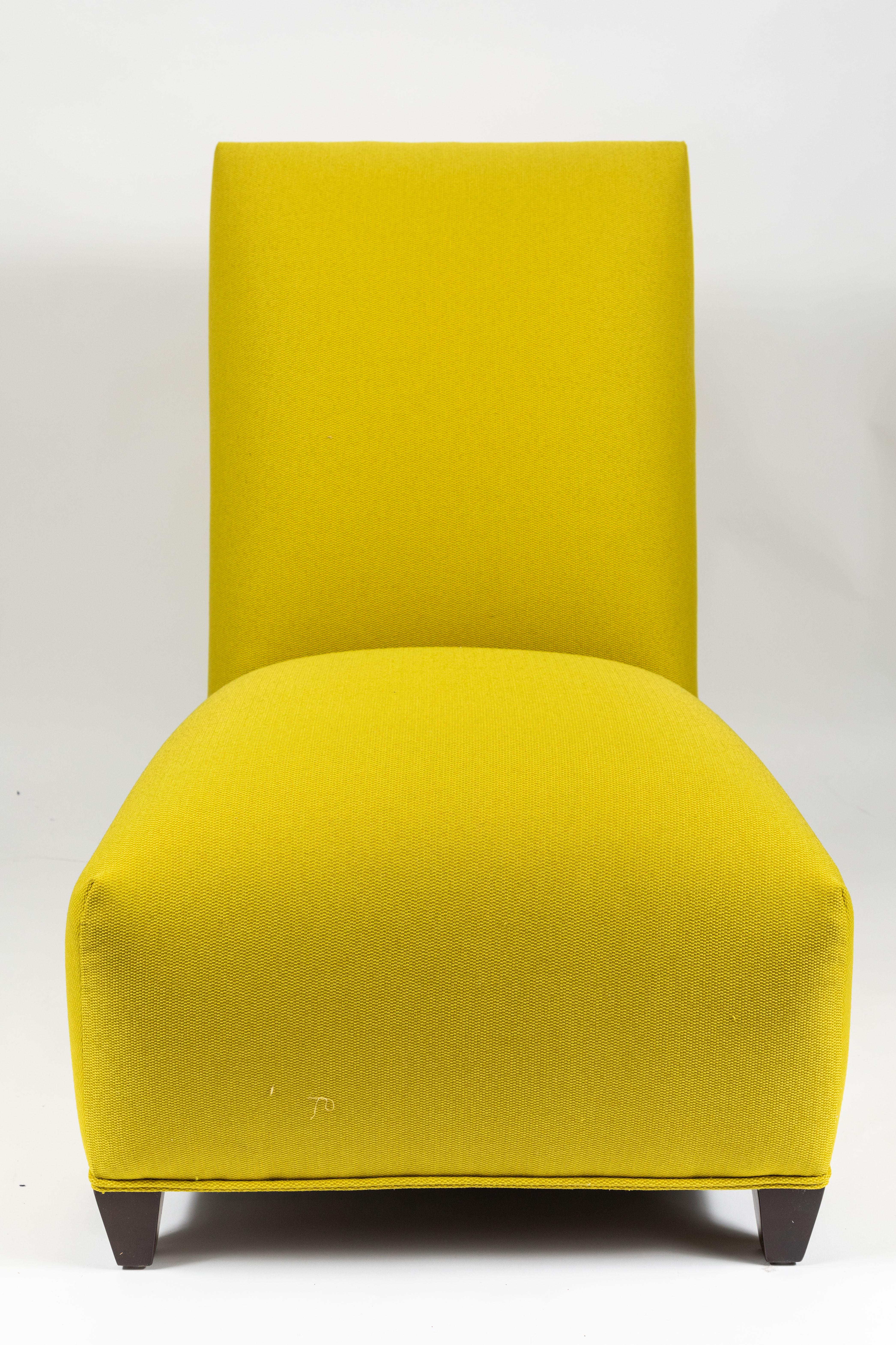 A pair of minimal and sleek slipper chairs by Donghia, circa 1980s. Newly re-upholstered in imported citrine color wool. Donghia tags on the underside of each chair.