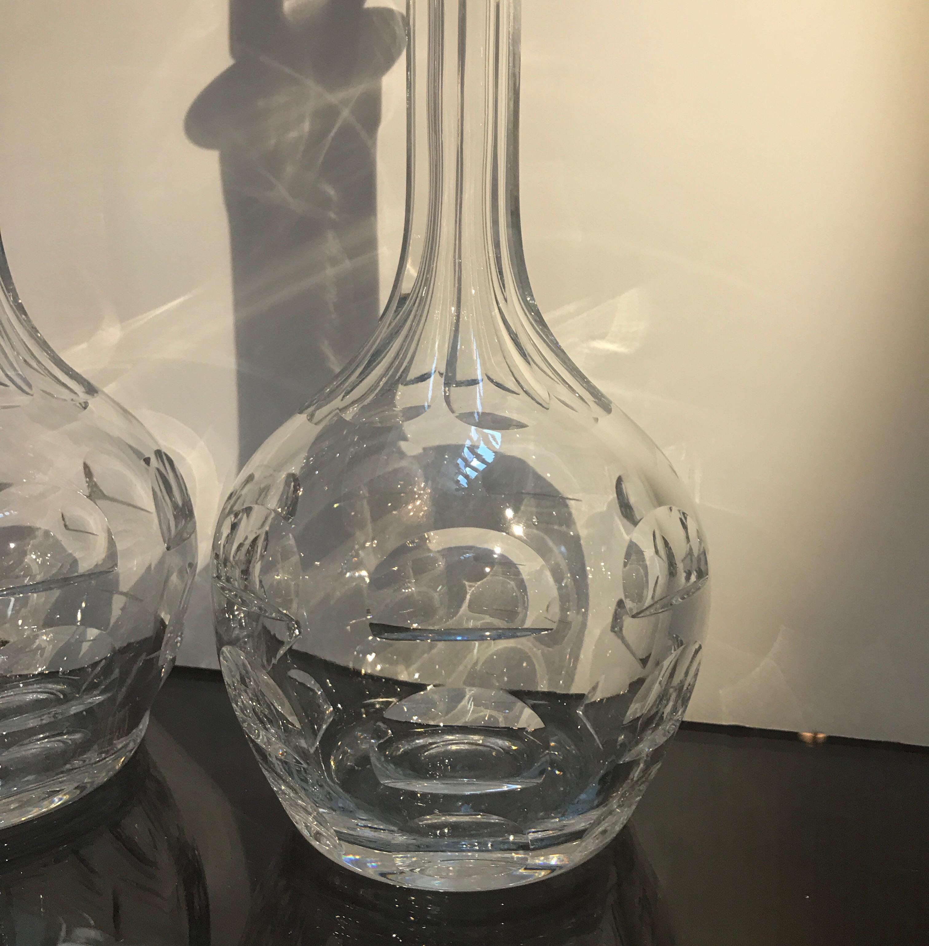 A chic pair of water clear Swedish crystal decanters. The bulbous bottoms with panel cut long necks with slender faceted stoppers.
Signed Orrefors on the bottom of each. Designed by Sven Palqvist