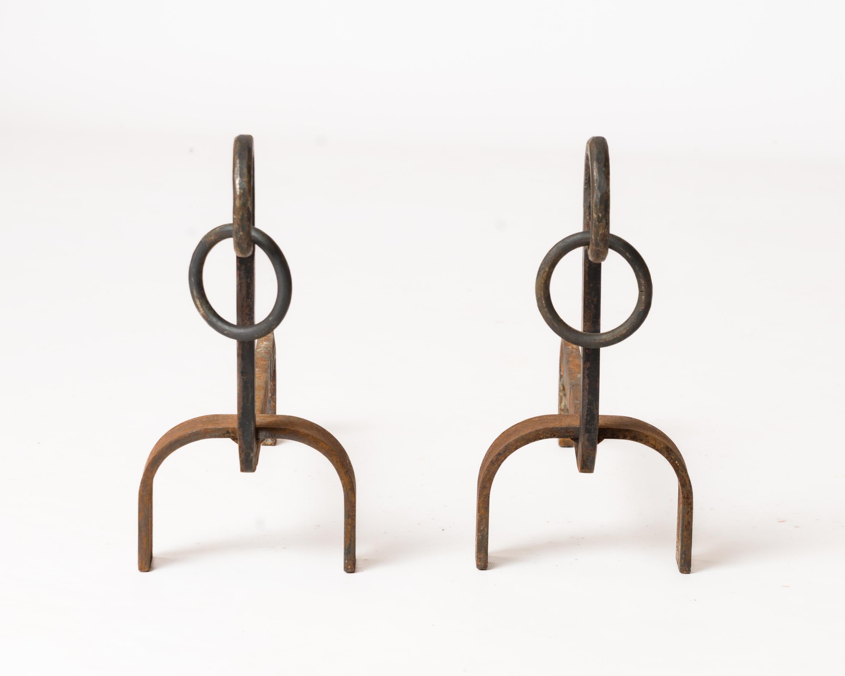 Elegante y minimalista par de morillos de hierro forjado con aros colgantes en las varillas de acabado. En buen estado vintage. 
Estos morillos se envían desde Francia y pueden devolverse a Francia o a un centro del norte del estado de Nueva York.