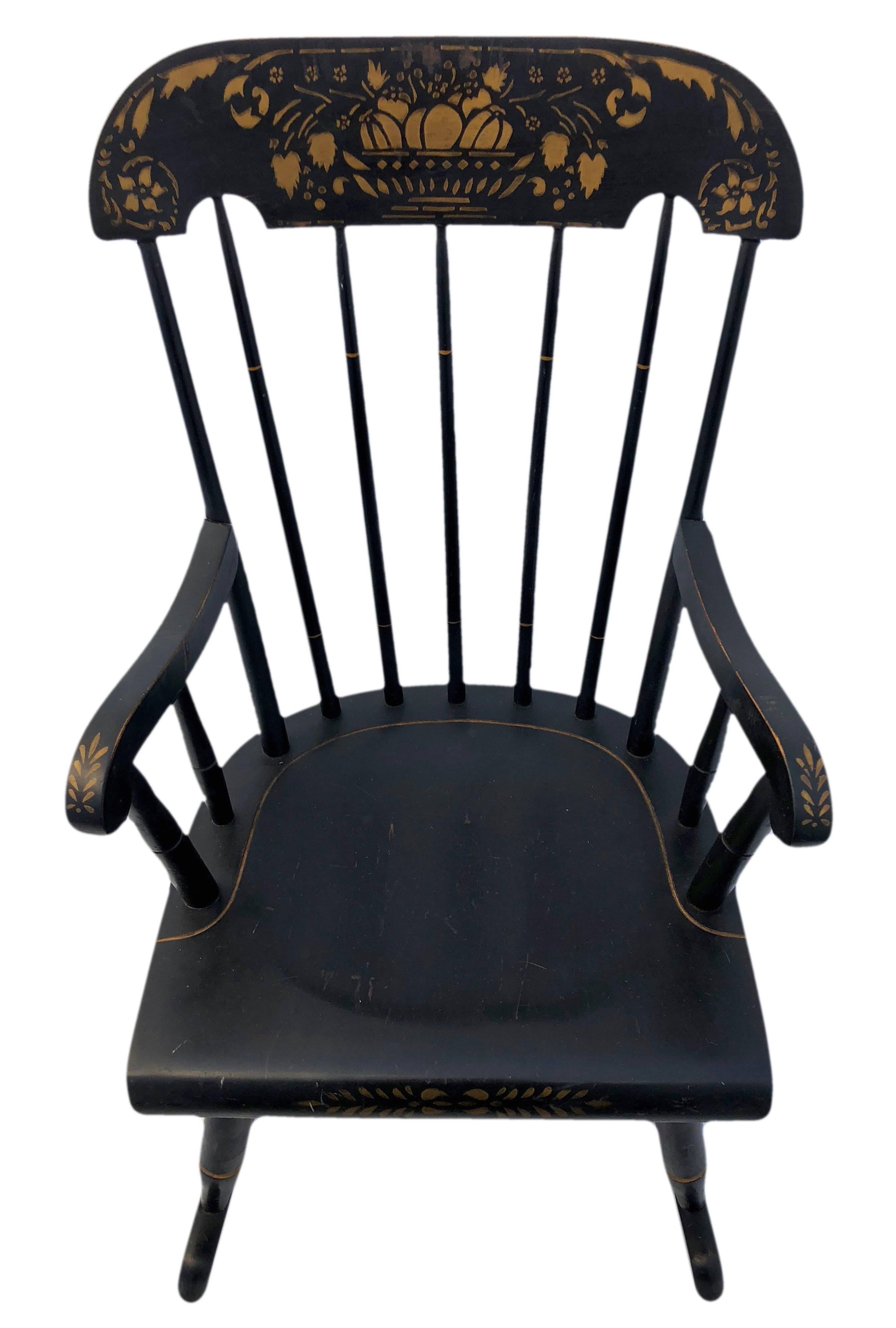 These are a pair of adorable Hitchcock style child’s rocking chairs. The Windsor rocking chair features a classic style with wide carved top rail, spindle back, short curved arms with spindle support, and long platform rockers. The chairs have been