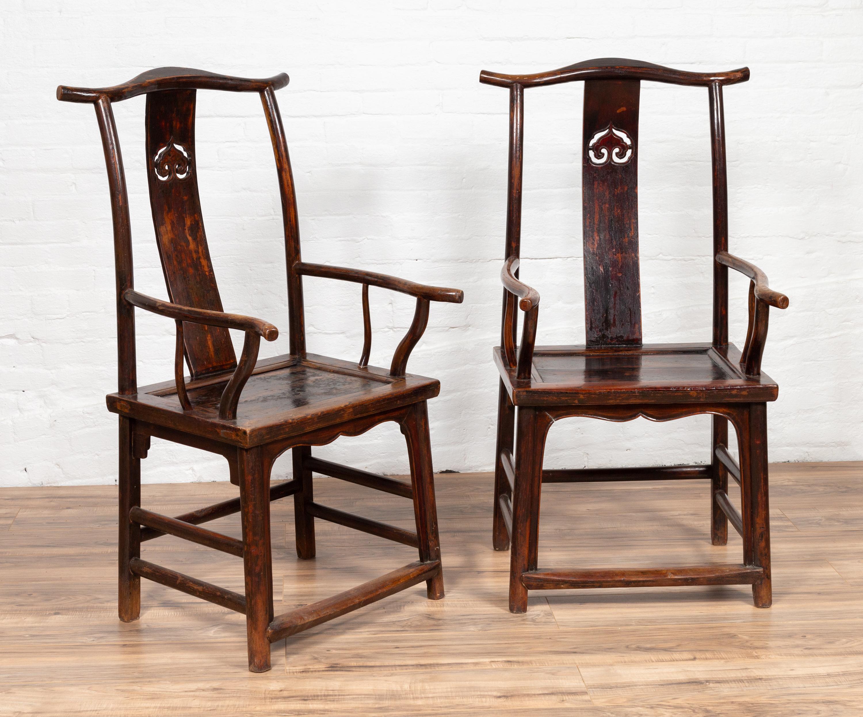 A pair of Chinese official's hat armchairs from the late 19th century, with carved splats, curving structures, scalloped aprons and side stretchers. We currently have two pairs available, priced and sold per pair. Born in the last quarter of the