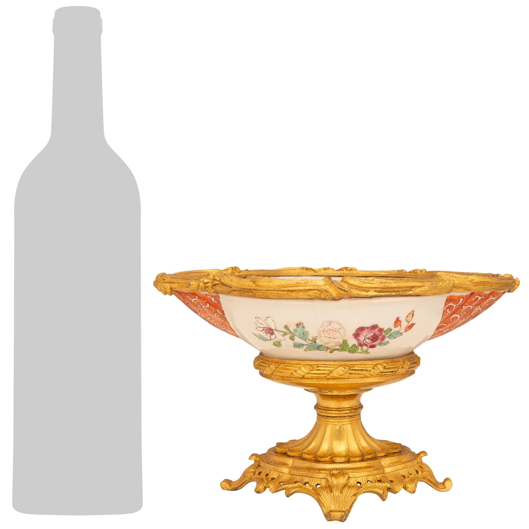 Une élégante et charmante paire de centres de table en porcelaine de la famille rose chinoise du XVIIIe siècle et en bronze doré français du XIXe siècle. Chaque pièce centrale est surmontée d'une base ovale percée en bronze doré, dont le fond est