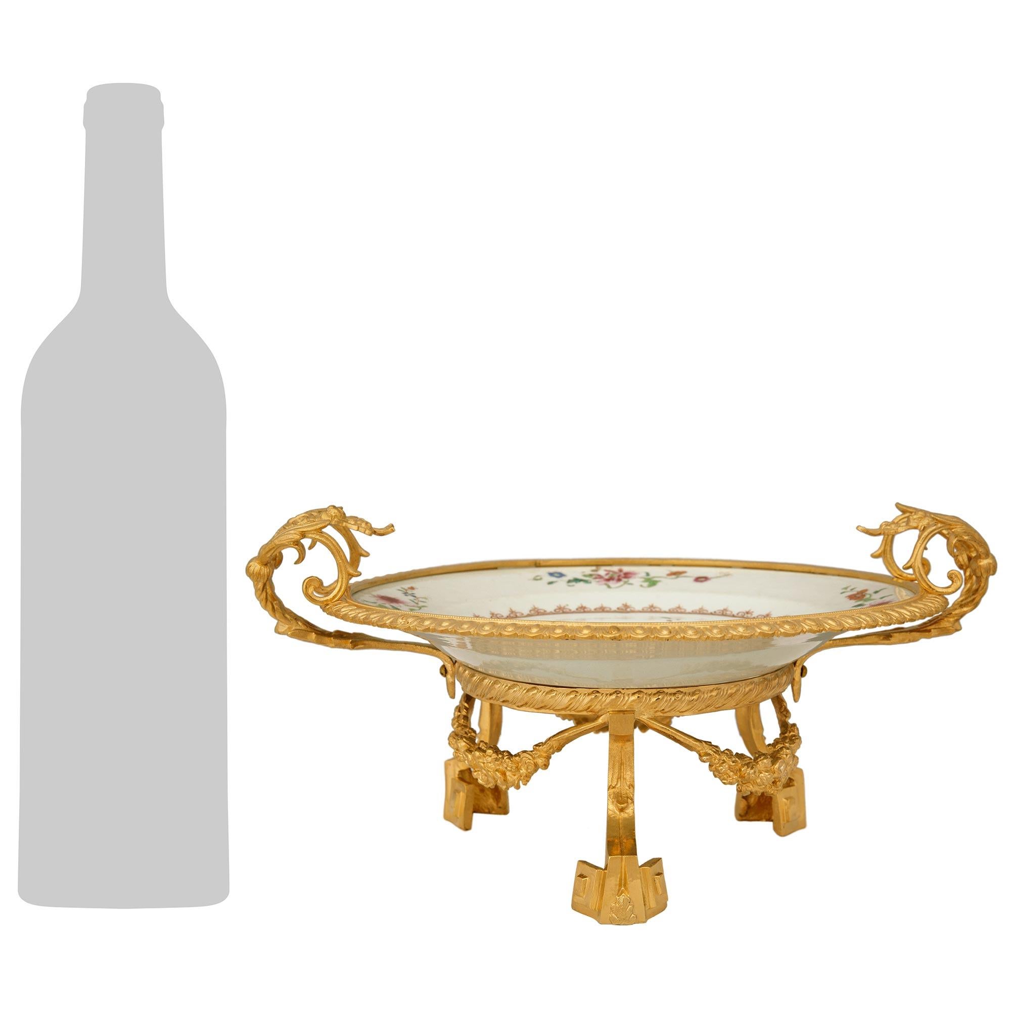 Une paire très élégante de centres de table en porcelaine Famille Rose chinoise du XVIIIe siècle et en bronze doré Louis XVI du XIXe siècle. Chaque magnifique pièce centrale repose sur une base circulaire en bronze doré ajouré avec des pieds en
