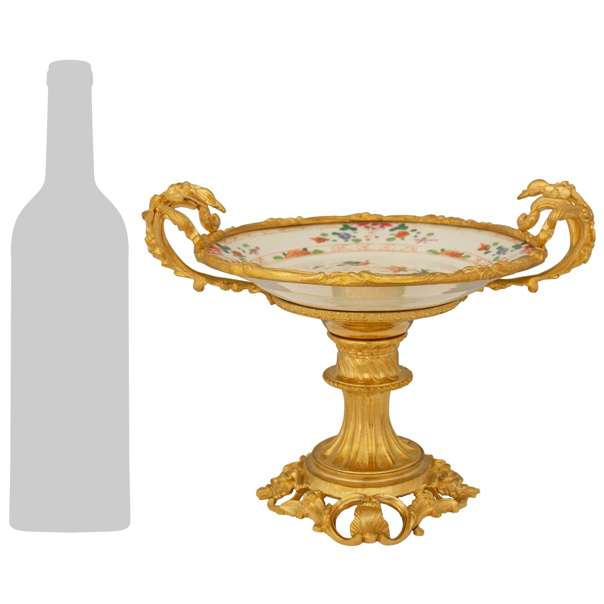 Une paire très élégante de centres de table en porcelaine Famille Rose chinoise du XVIIIe siècle et en bronze doré Louis XVI du XIXe siècle. Chaque magnifique présentoir repose sur une base circulaire en bronze doré ajouré, ornée de motifs