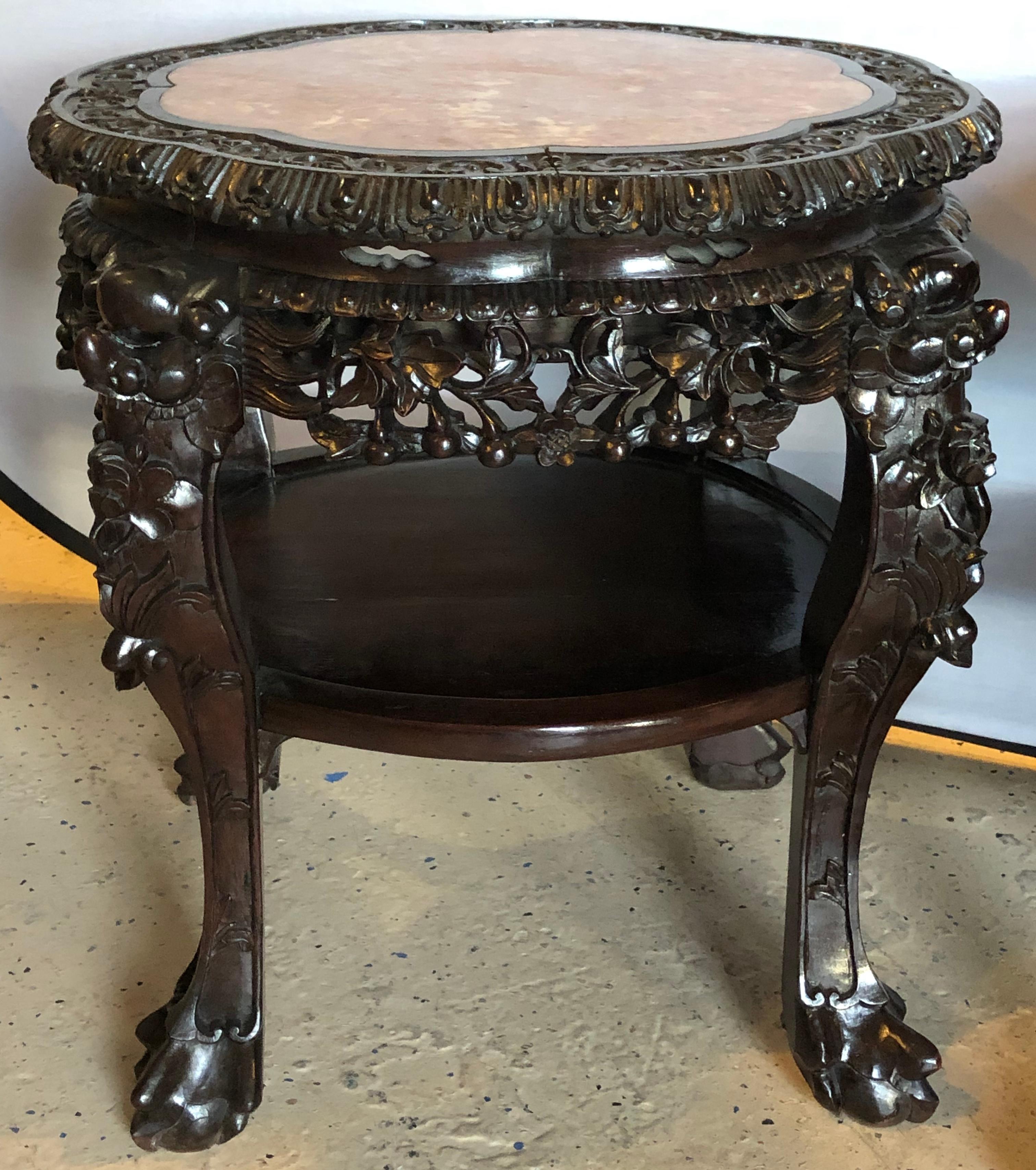 Pair of Chinese 19th century teak-wood marble-top stands or end tables. Each marble top stand having a carved teak stand with a lower shelf. The marbles having been professionally repaired and the marbles and cases having been polished.