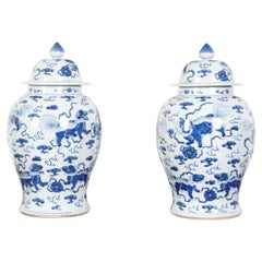 Pair of Chinese 1920s White and Blue Porcelain Lidded Vases with Guardian Lions