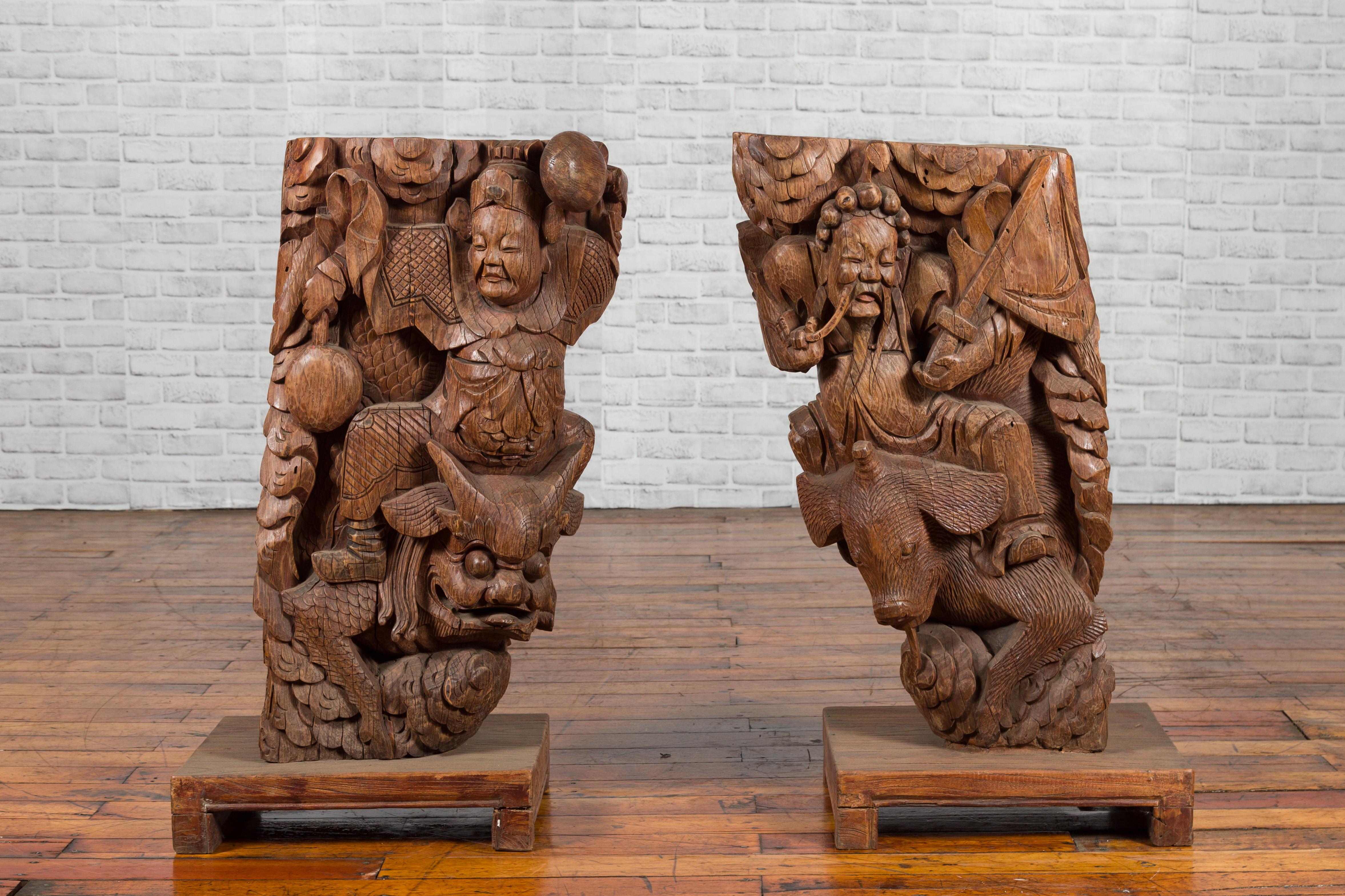 A pair of Chinese Qing Dynasty hand carved temple corbels from the early 19th century, depicting warriors. Created in China during the Qing Dynasty, this pair of Chinese temple corbels was skillfully hand carved in wood. Each corbel depicts a