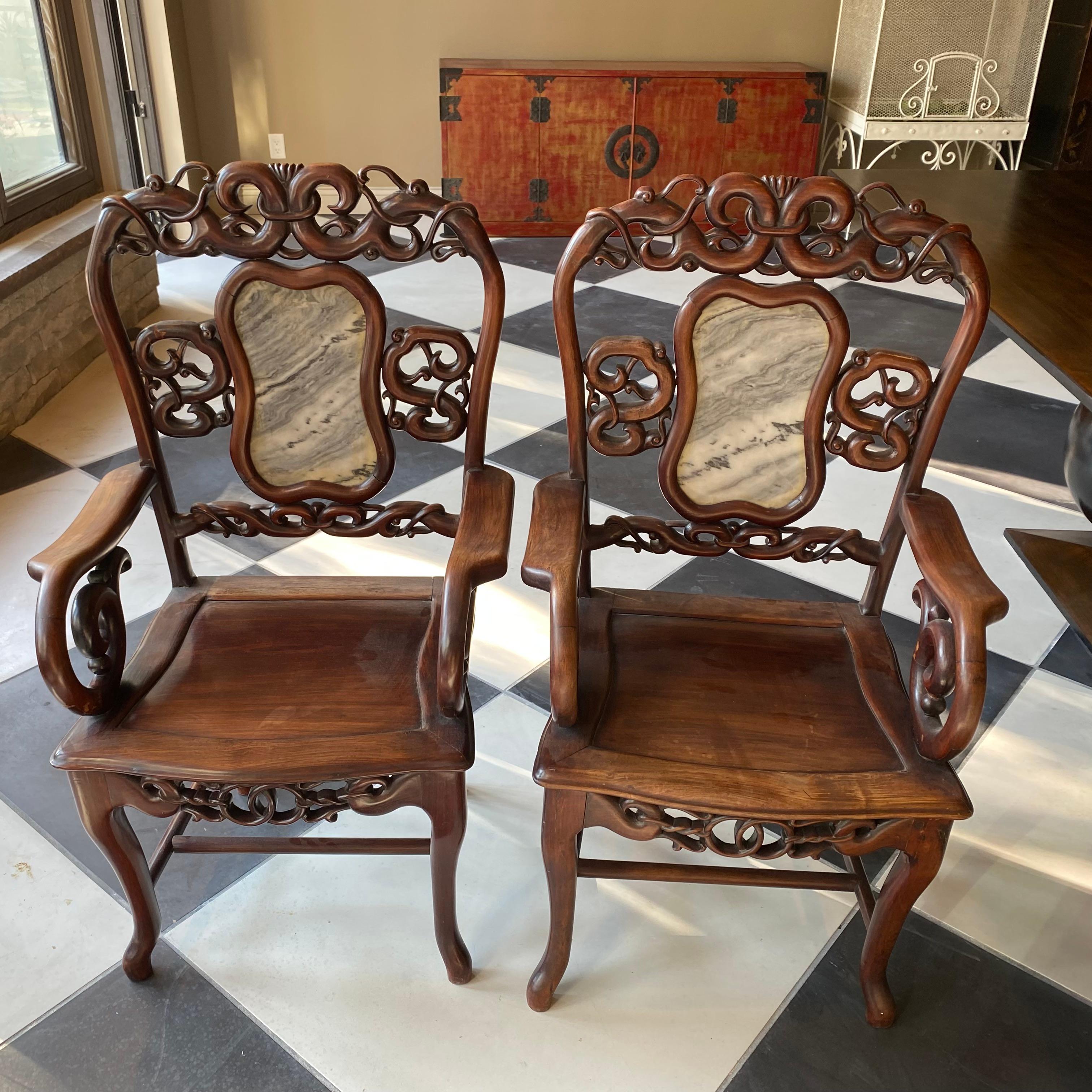 This wonderful pair of Chinese antique Mahogany wood armchairs are hand crafted having a marble back splat in each. These marble pieces represent the landscape on the countryside. These where made for aristocrats or officials. Beautiful patina!