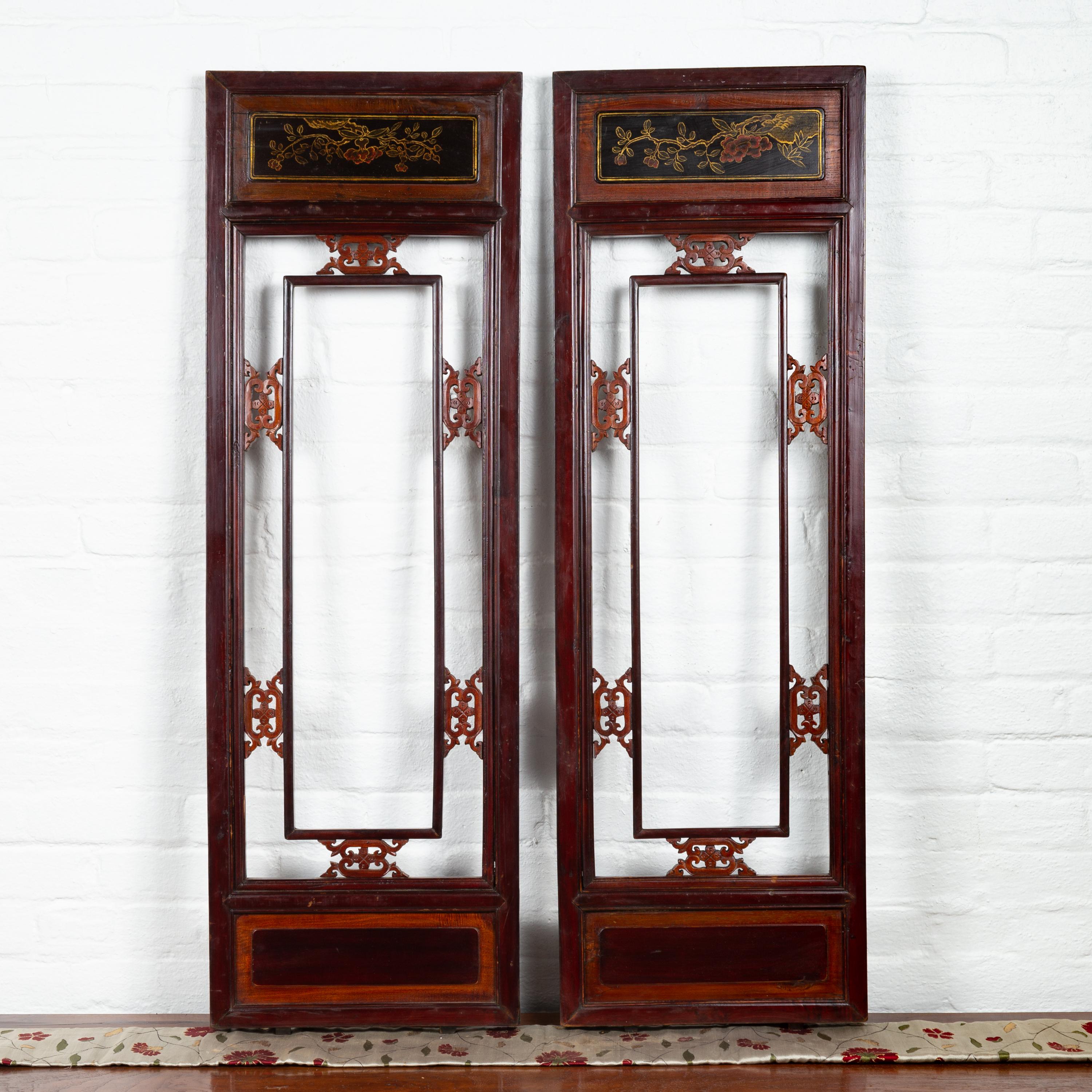 A pair of Chinese antique carved wooden panels from the early 20th century, with red and brown patina and golden accents. Born in China during the early years of the 20th century, each of these decorative panels features a reddish brown colored