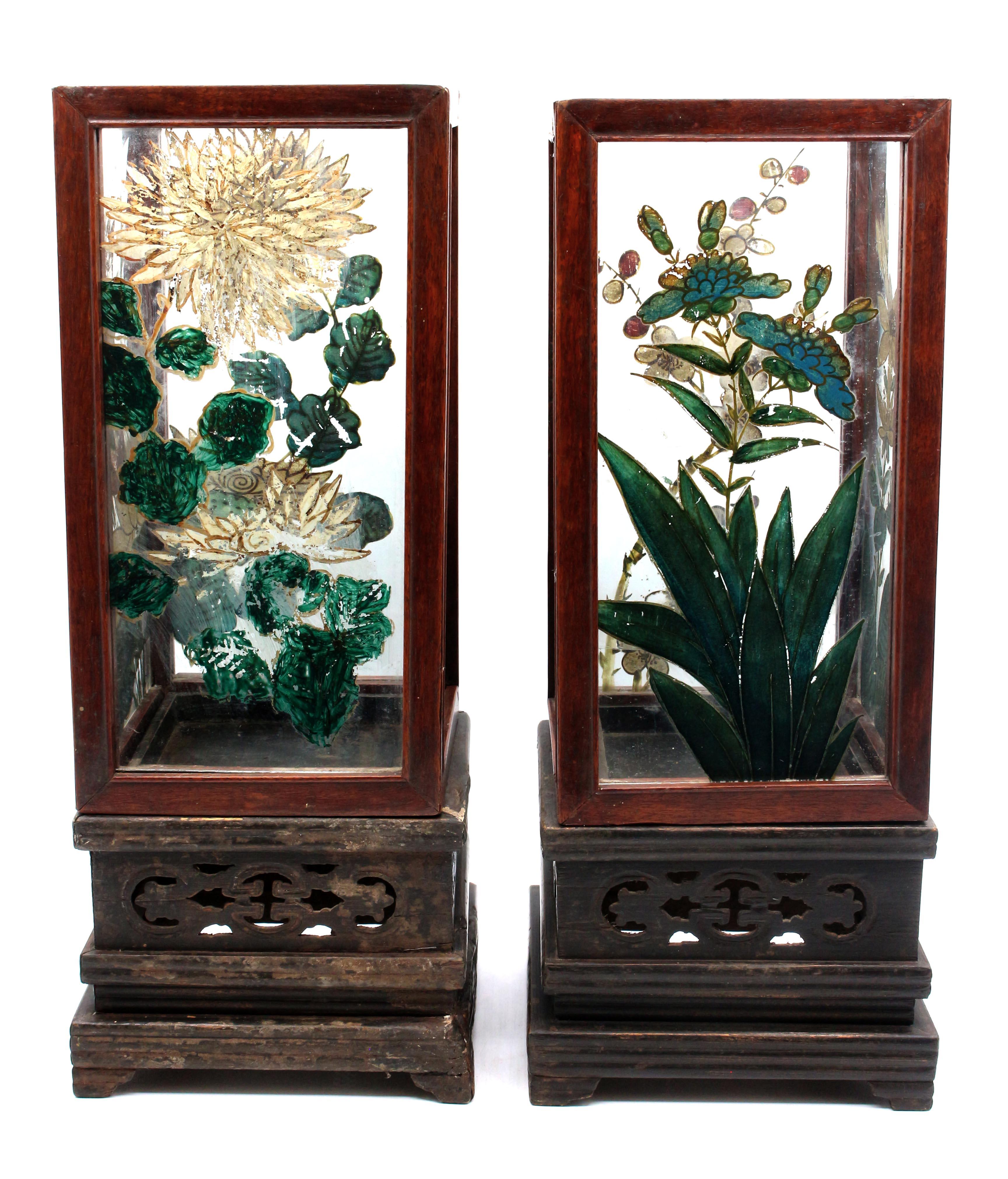 Pair of Chinese bedside lanterns, circa 1900, Qing dynasty. Eglomise glass panels of flowers (worn) in teak frame on carved stained hardwood bases. Provenance: The Estate of artist Louis St. Lewis, Chapel Hill, NC (St. Lewis apprenticed with Andy