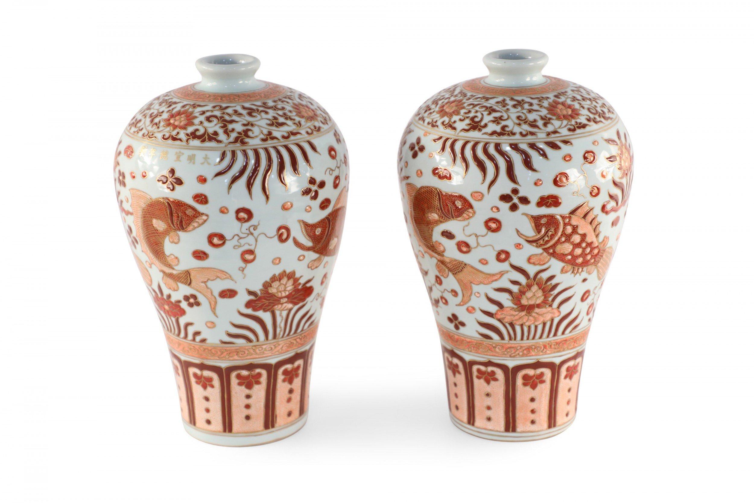 Pair of Chinese beige porcelain vases with Meiping forms decorated in orange fish and flower motifs and geometric-patterned bands around the tops and bases, accented in gold detailing.