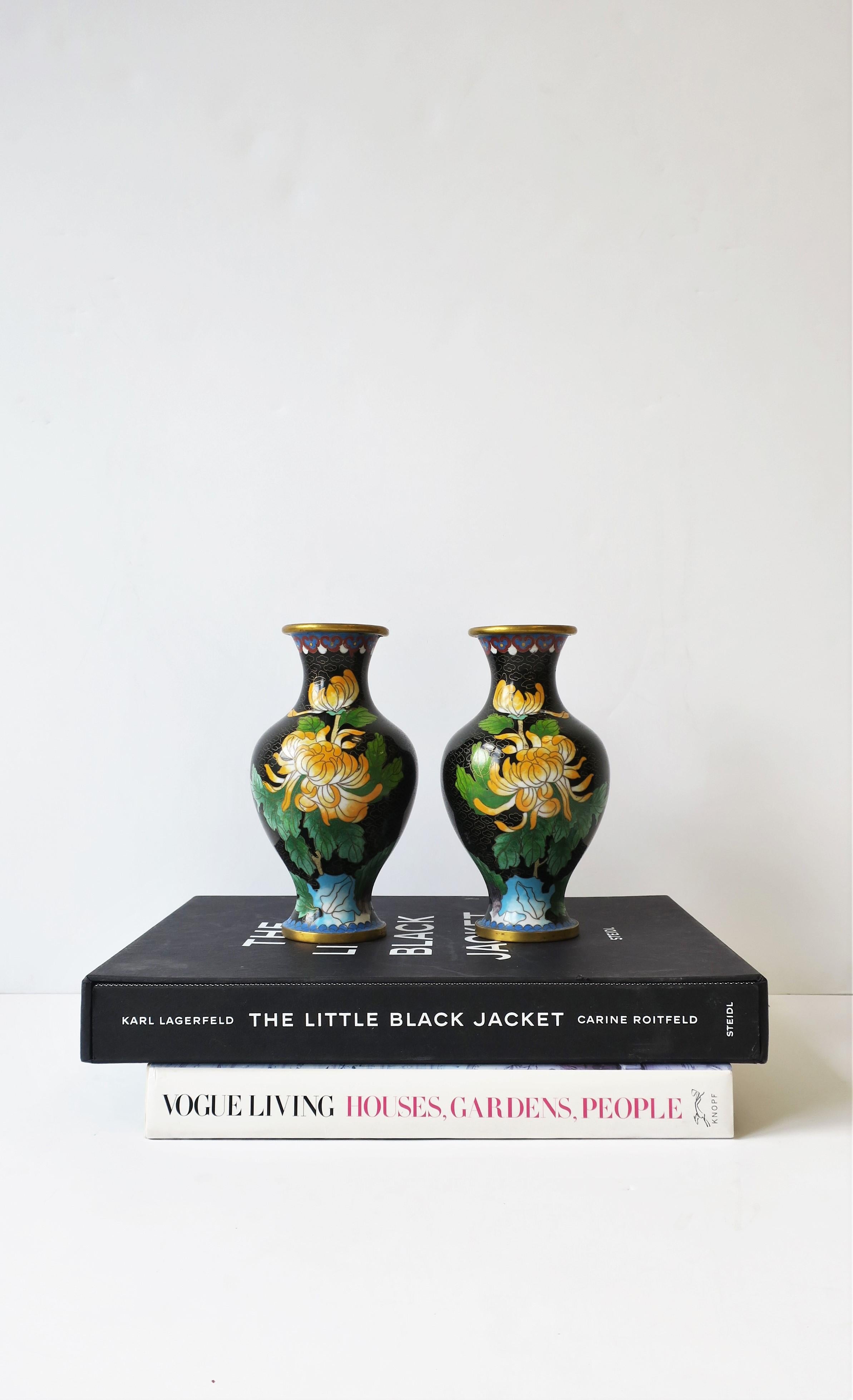 A beautiful pair of predominantly black, 'Emerald' green and orange, Asian cloisonné´ and brass vases, circa 20th century, Japan. Beautiful, detailed design of spider chrysanthemum flowers and butterflies. Enamel colors include black, 'Emerald' or