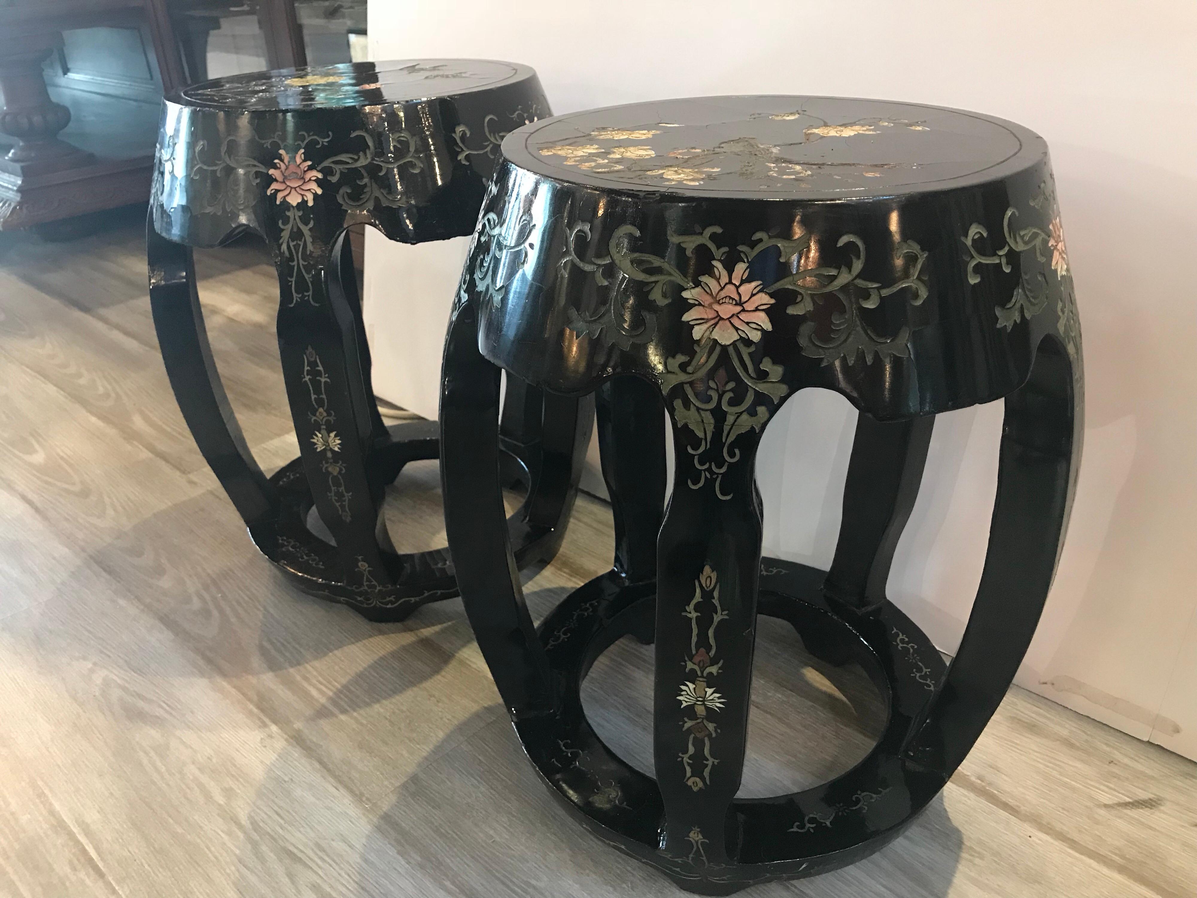 Elegant pair of black lacquer garden sear shaped stands from the Hollywood Regency period. The original black lacquer with Classic Chinese relief floral and bird decoration. The round stands with five legs with circular base. The finish has age