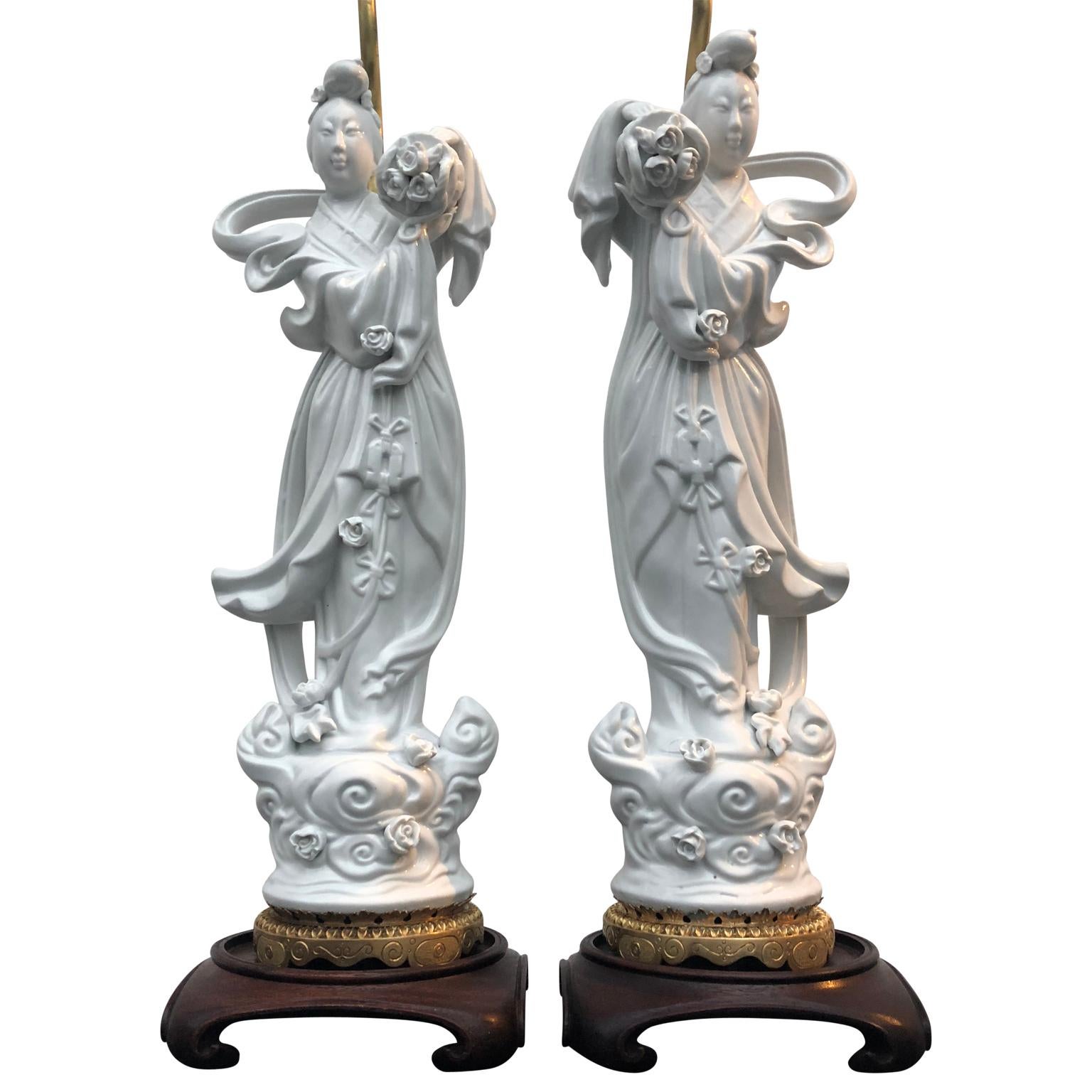 Pair of early 20th century Chinese Blanc de Chine Guanyin table lamps.

The porcelain lamps are standing on a gilded bronze lotus leaf base.
        