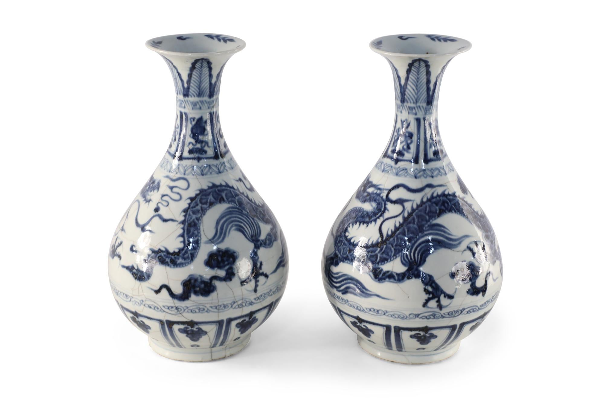 Pair of Chinese blue and white porcelain vases with jade pot spring bottle forms traditionally found in Chinese porcelain, a dragon design that is painted in the style of the Yuan Dynasty, and crazing (date mark on bottoms).