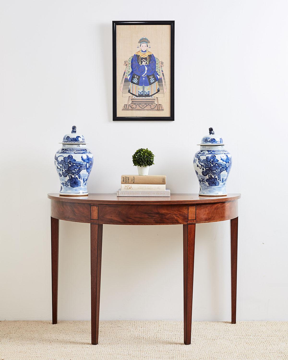 Wunderschönes Paar chinesischer blau-weißer Ingwerdosen mit Blumenmotiv und Foo-Dog-Henkeln an der Oberseite. Diese Deckelgefäße oder Vasen sind mit Flora und Fauna über einer Wasserlandschaft mit Vögeln geschmückt. Schön geformt und mit einer Da