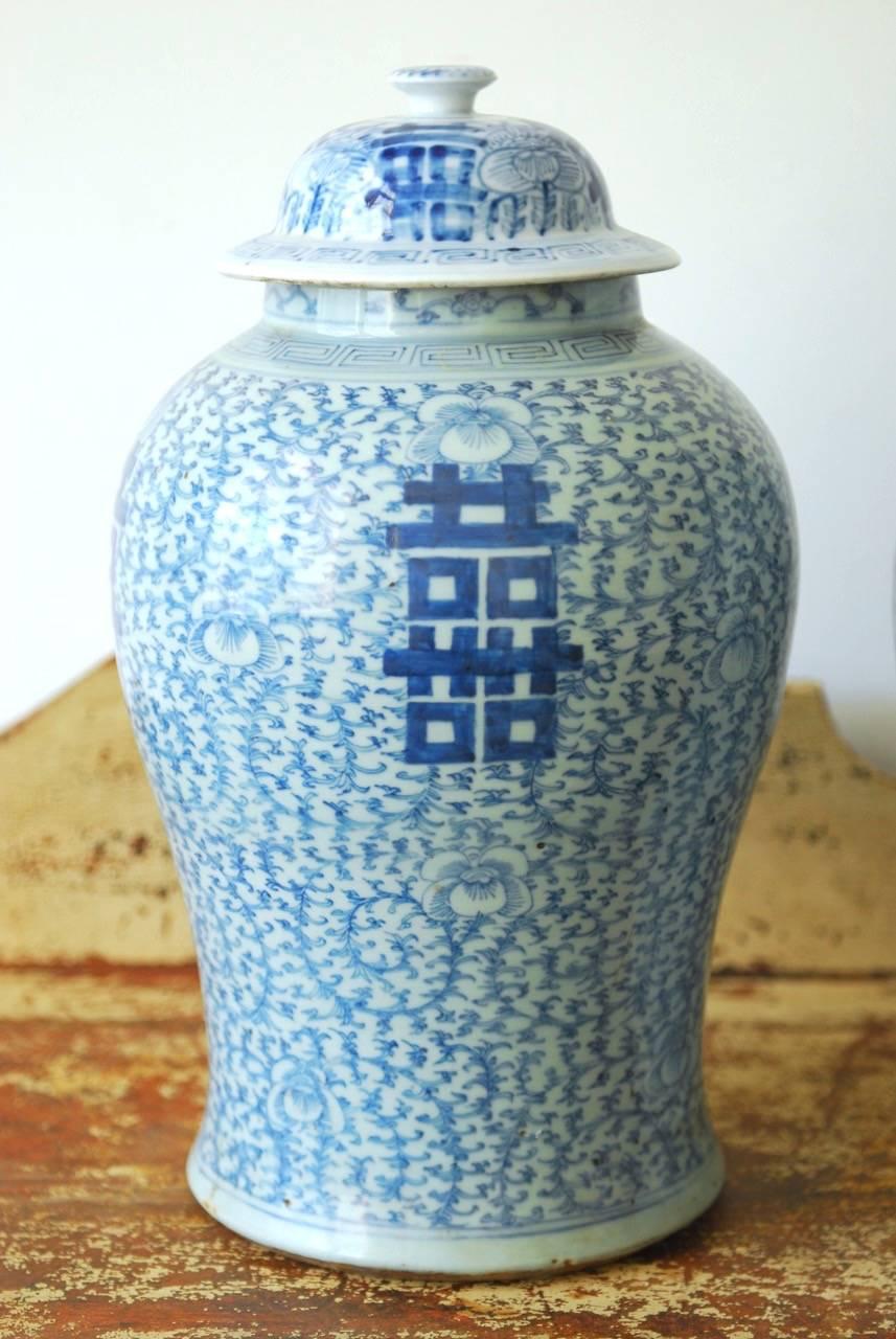 Remarkable pair antique Chinese blue and white Ginger Jars or Temple Jar vases. Featuring a scrolling vine pattern background and double happiness design on each. Very slight variations in form with a pleasing faded finish. Chenghua Ming period mark