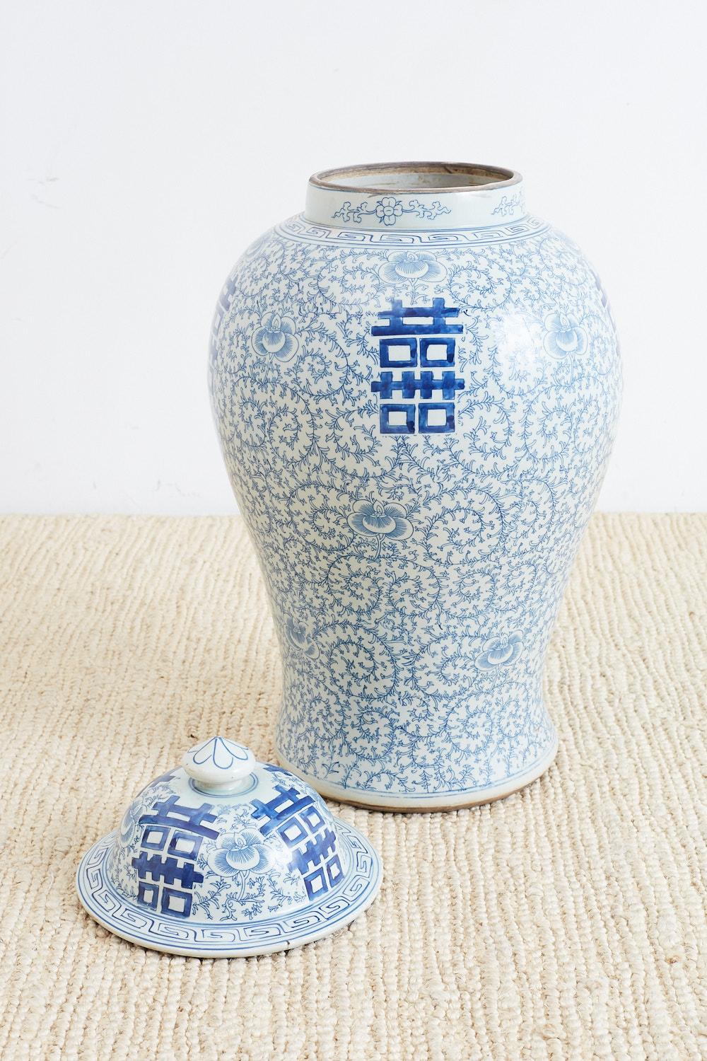 Gorgeous pair of large Chinese blue and white porcelain ginger jars featuring Shuangxi double happiness or wedded bliss symbols. The large lidded jars are decorated with a scrolling vine pattern and a Greek key border on the neck and brim.