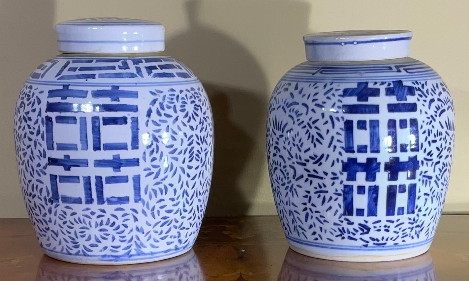 Paar chinesische Ingwerdosen aus blauem und weißem Porzellan, handbemalt mit stilisiertem Blattwerk und doppeltem Glückssymbol in der Mitte, 20. Jahrhundert, schönes Ausstellungsstück.
Größen: 8 