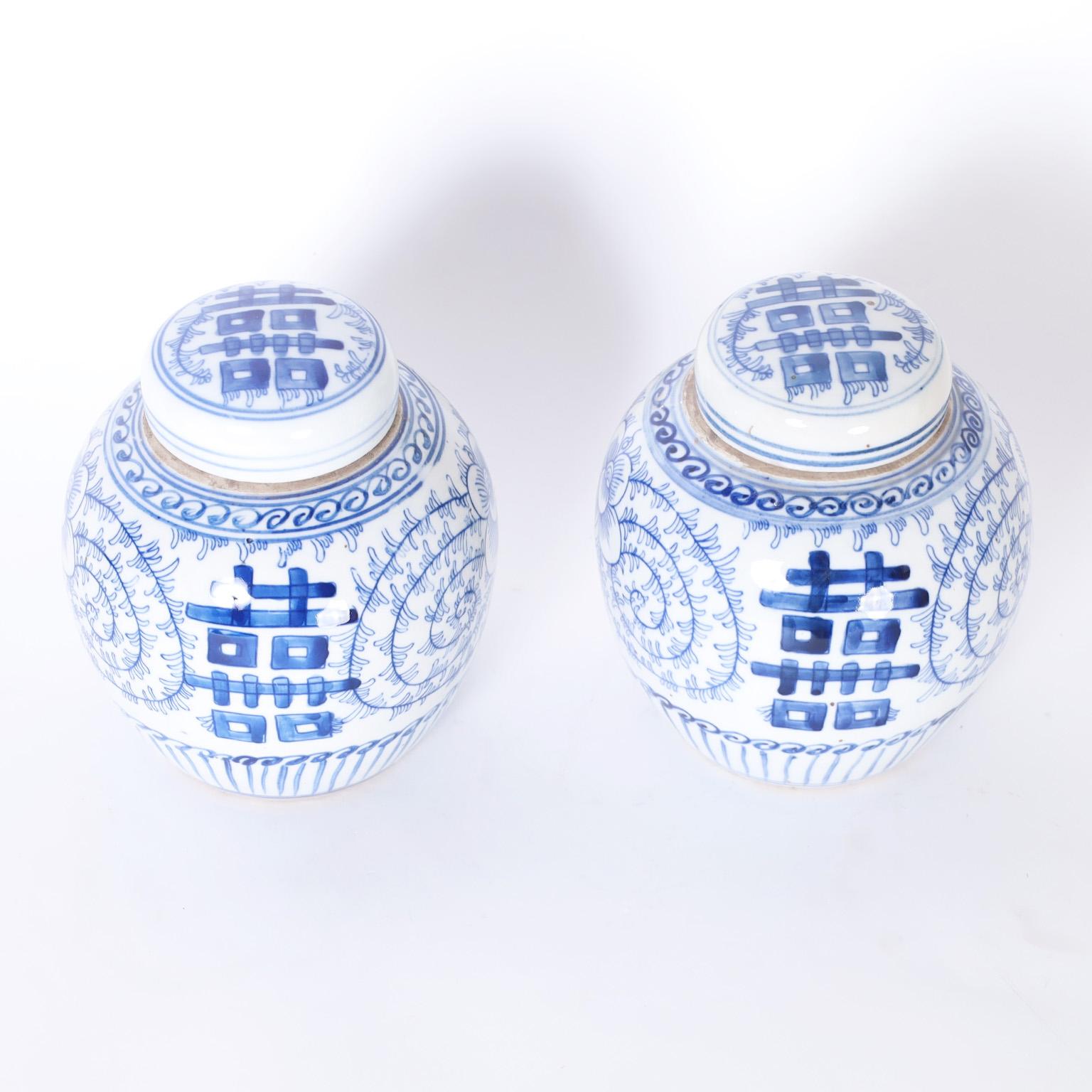Originally a wish for a happy marriage the double happiness symbol is iconic, here we present a pair of lidded tea caddies hand decorated with a floral background.