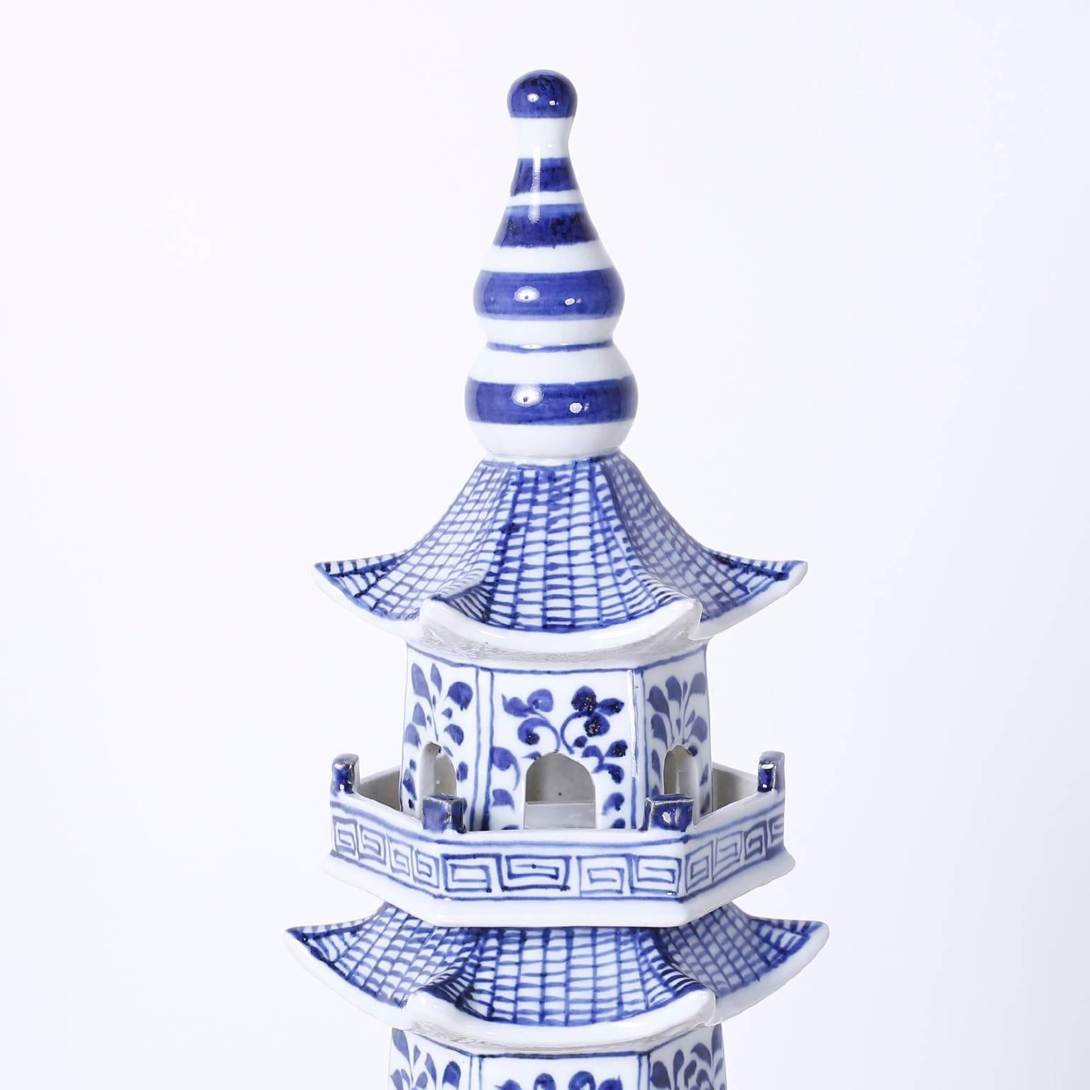 Dramatic tall Chinese blue and white pagodas, in the Chinese export style, assembled from eight
separate porcelain pieces with each hand decorated in traditional floral and geometric designs.