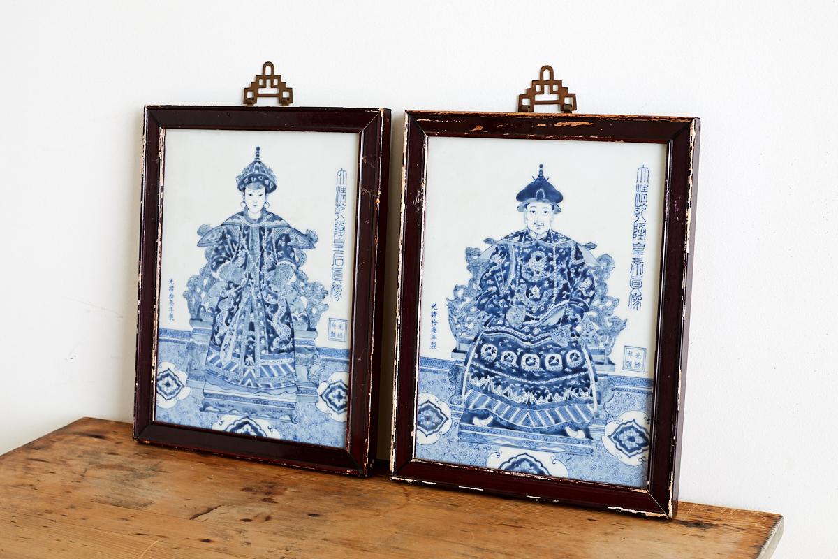 Remarkable pair of Chinese Qianlong style blue and white porcelain plaques depicting the emperor and empress. Hand-painted with period apocryphal Guangxu Nian Zao stamps (1875-1908). Each mounted in a wooden lacquered frame with a decorative brass