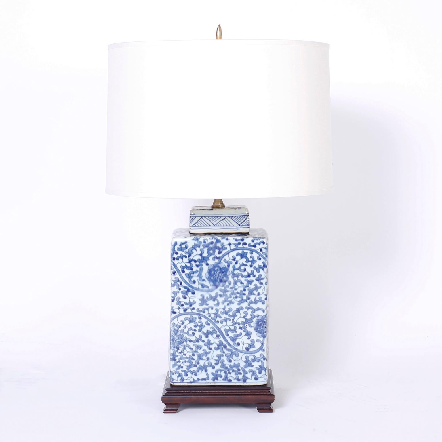 Lofty pair of Chinese porcelain table lamps with a square ginger jar form and decorated in lush floral designs and presented on mahogany bases.