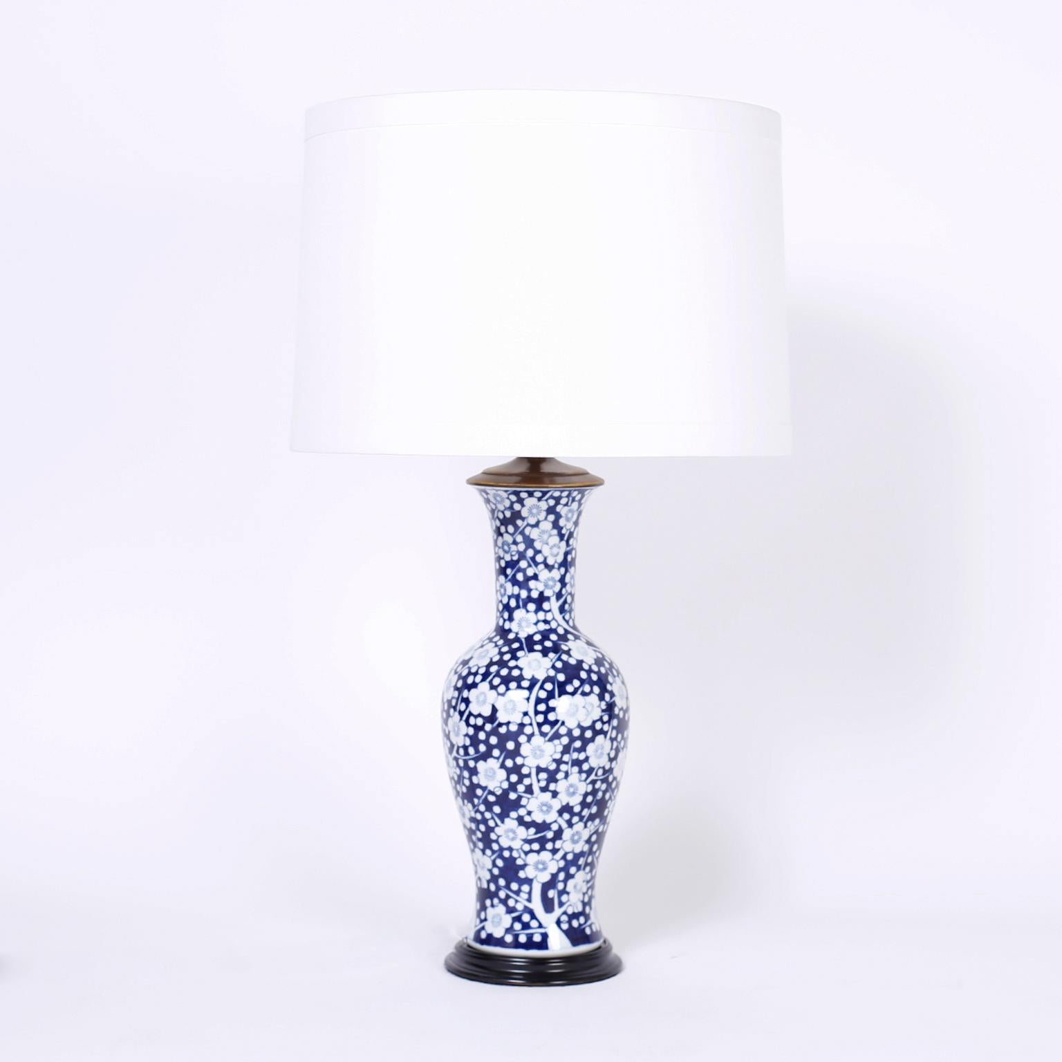 Pair of Chinese blue and white porcelain Prunus design table lamps with classic form, once vases now repurposed with delightful white floral designs on an alluring deep blue background.