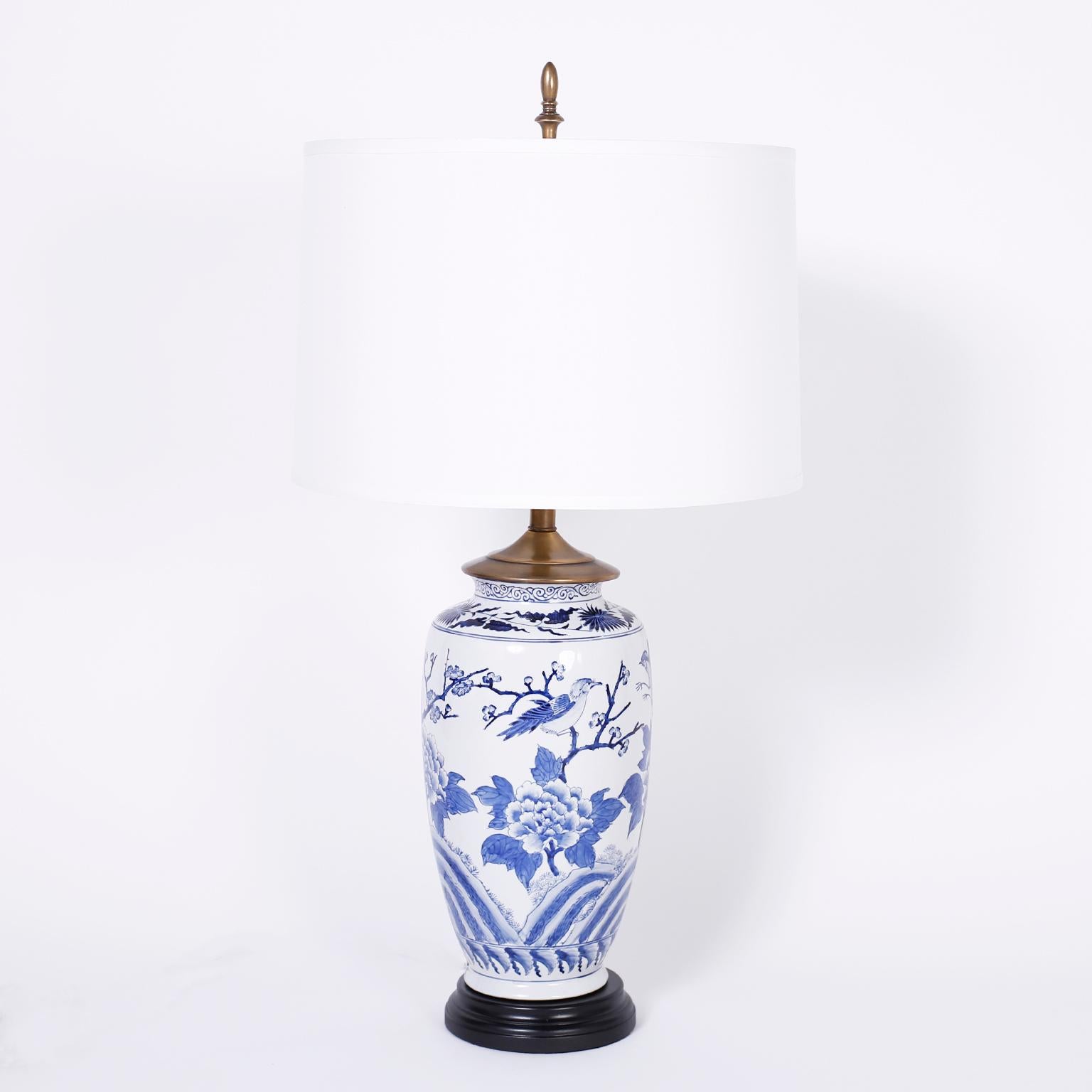 Pair of antique Chinese porcelain vases now table lamps decorated with classic chinoiserie birds and flowers presented on turned ebonized wood bases.