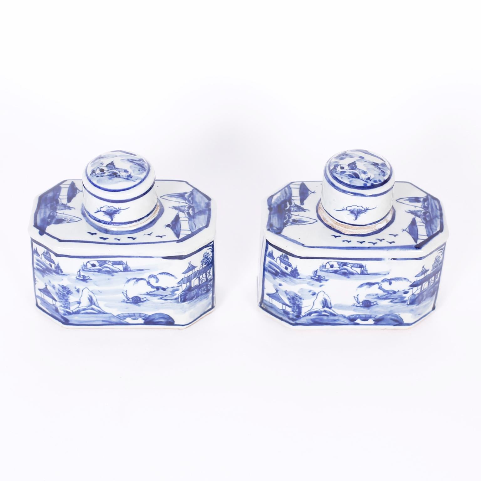 Pair of classic Chinese blue and white porcelain tea caddies with an unusual octagon form hand decorated with landscapes and waterways.