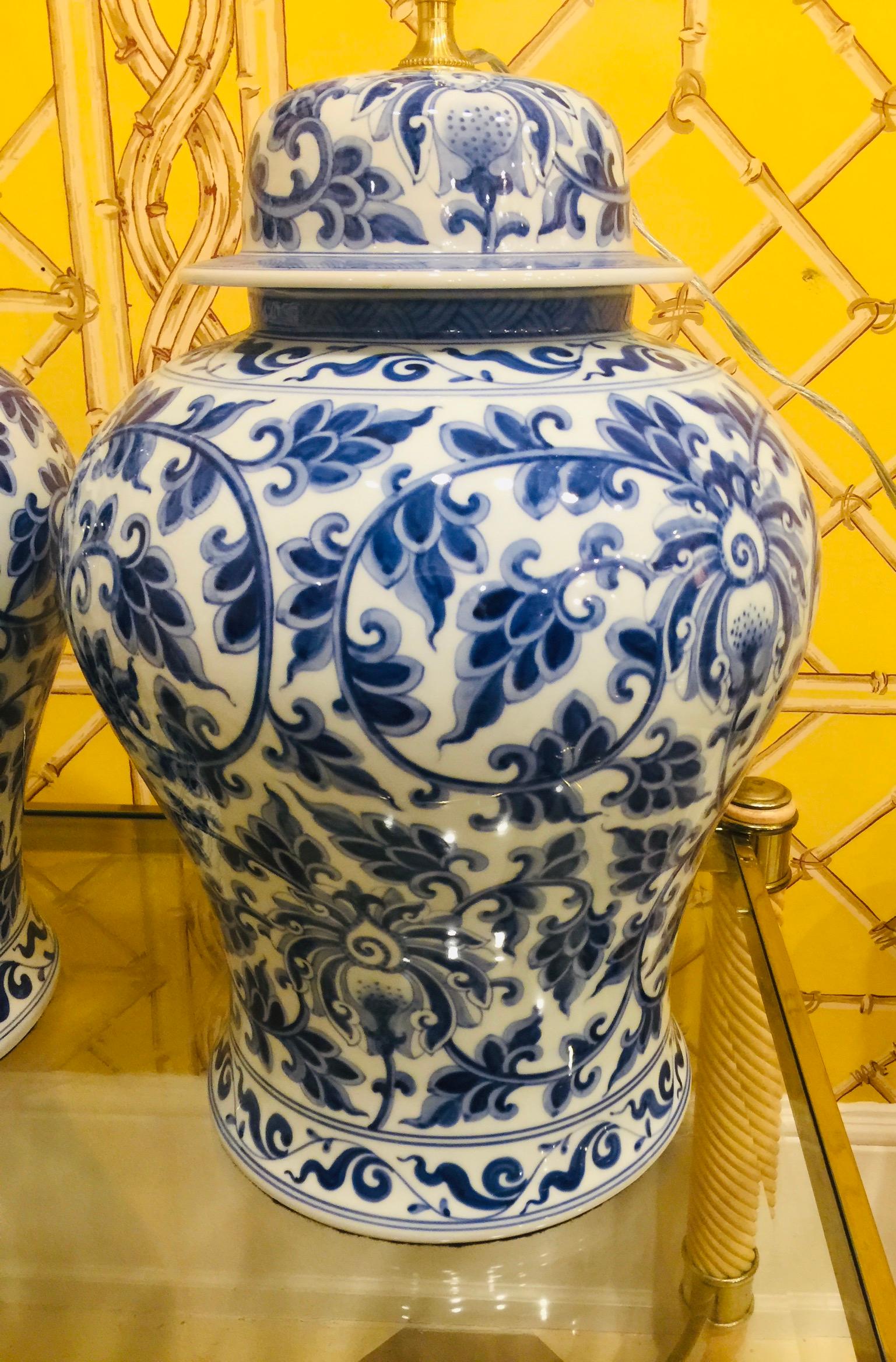 Pair of Chinese blue and white porcelain temple jar lamps
having a beautiful stylized blossom and leaf pattern, dark and light
blue coloring with original temple jar tops (new electrical work, wired from the top with wire coming out along the side