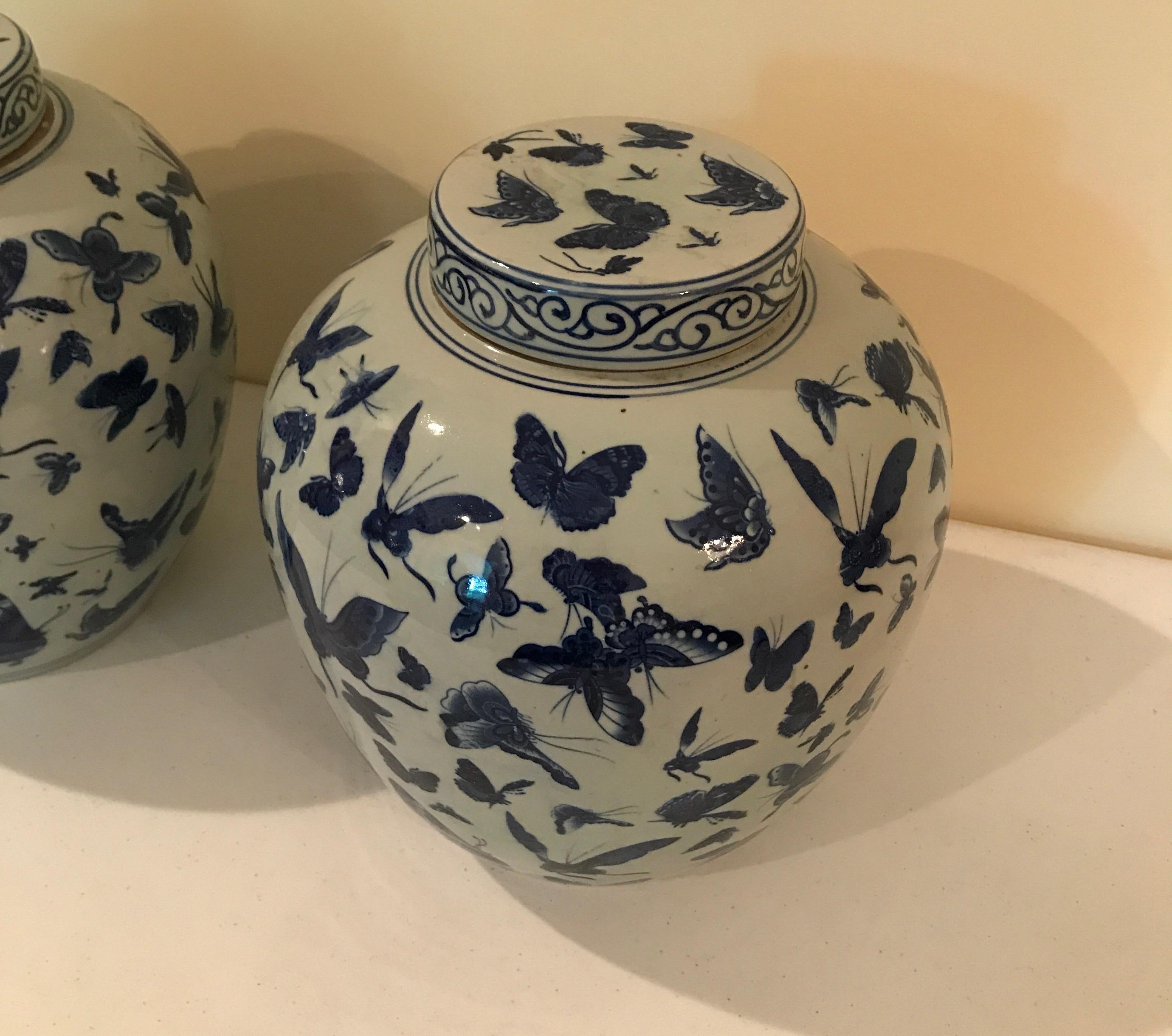 Pair of Chinese ginger jars with lids in a butterfly motif.