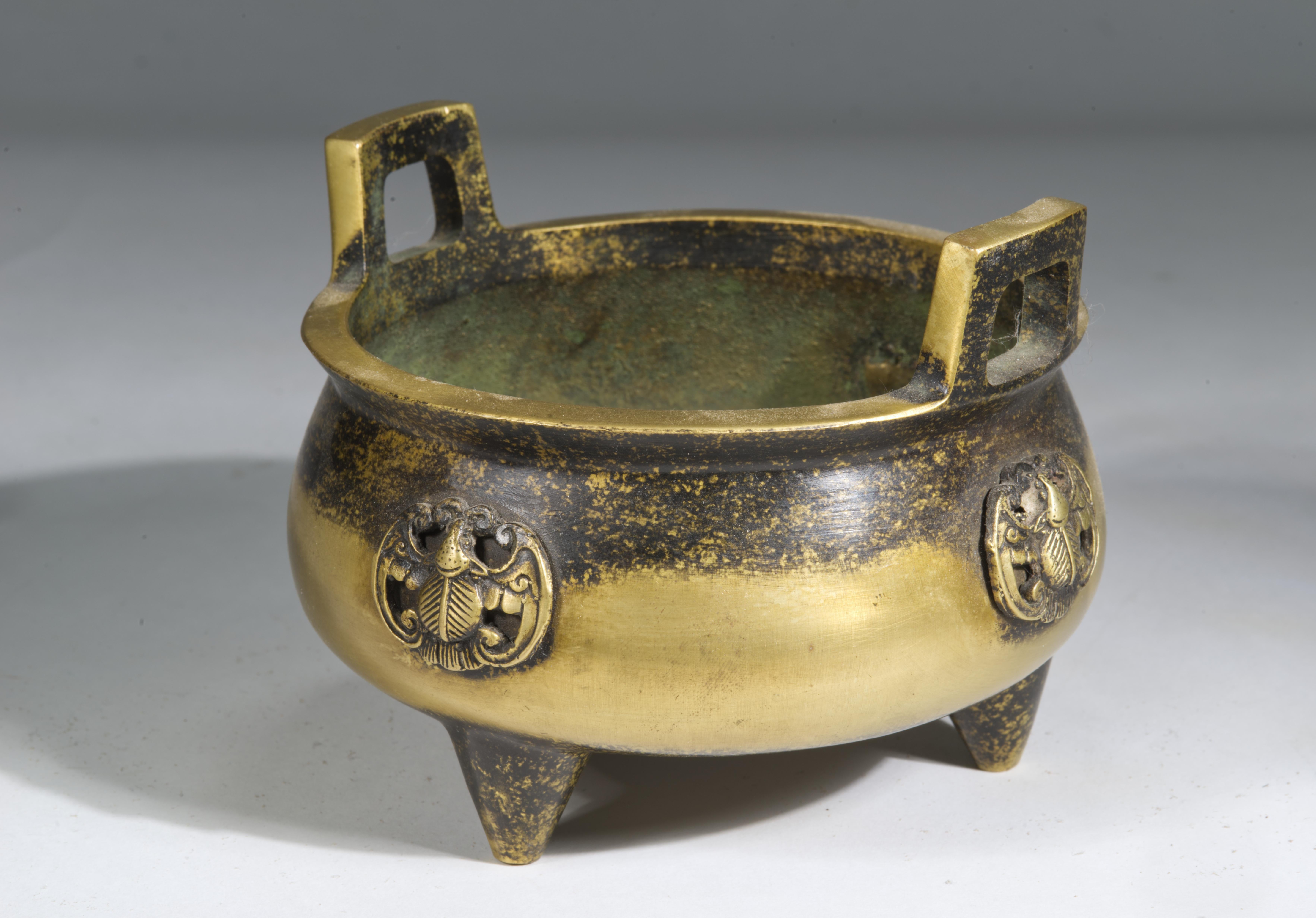  Coppia di incensieri cinesi in bronzo di ottima qualità, con forme a tripode a due manici, ampie aperture e accenti patinati. I corpi aperti e arrotondati con manici ad anello di taglio quadrato poggiano su piedi corti e robusti. Uno degli