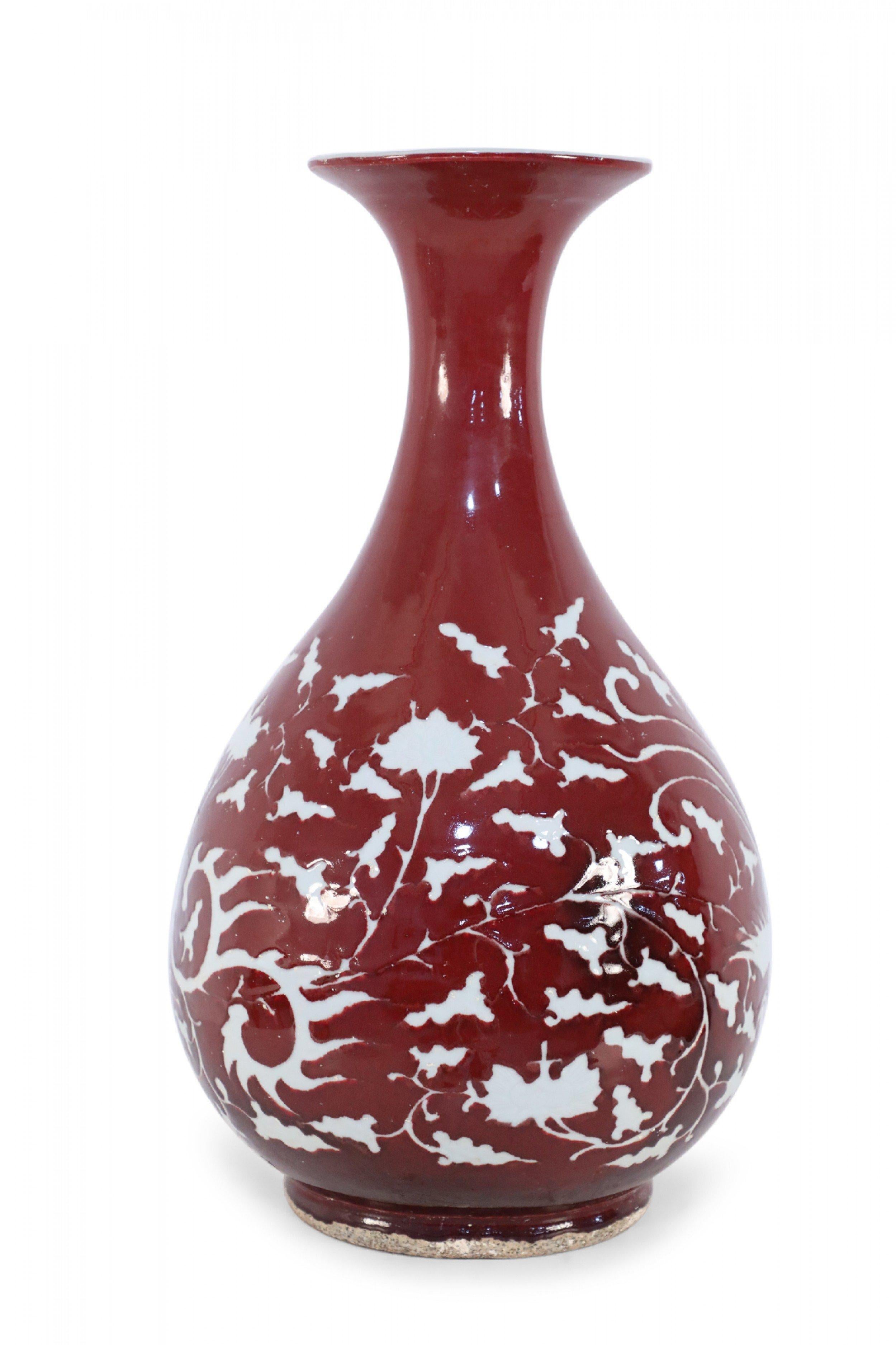 COPPIA di vasi cinesi in porcellana bordeaux decorati con motivi bianchi che catturano le silhouette di uccelli in mezzo alla natura, avvolgendo le loro forme a pera (PREZZO A COPPIA).