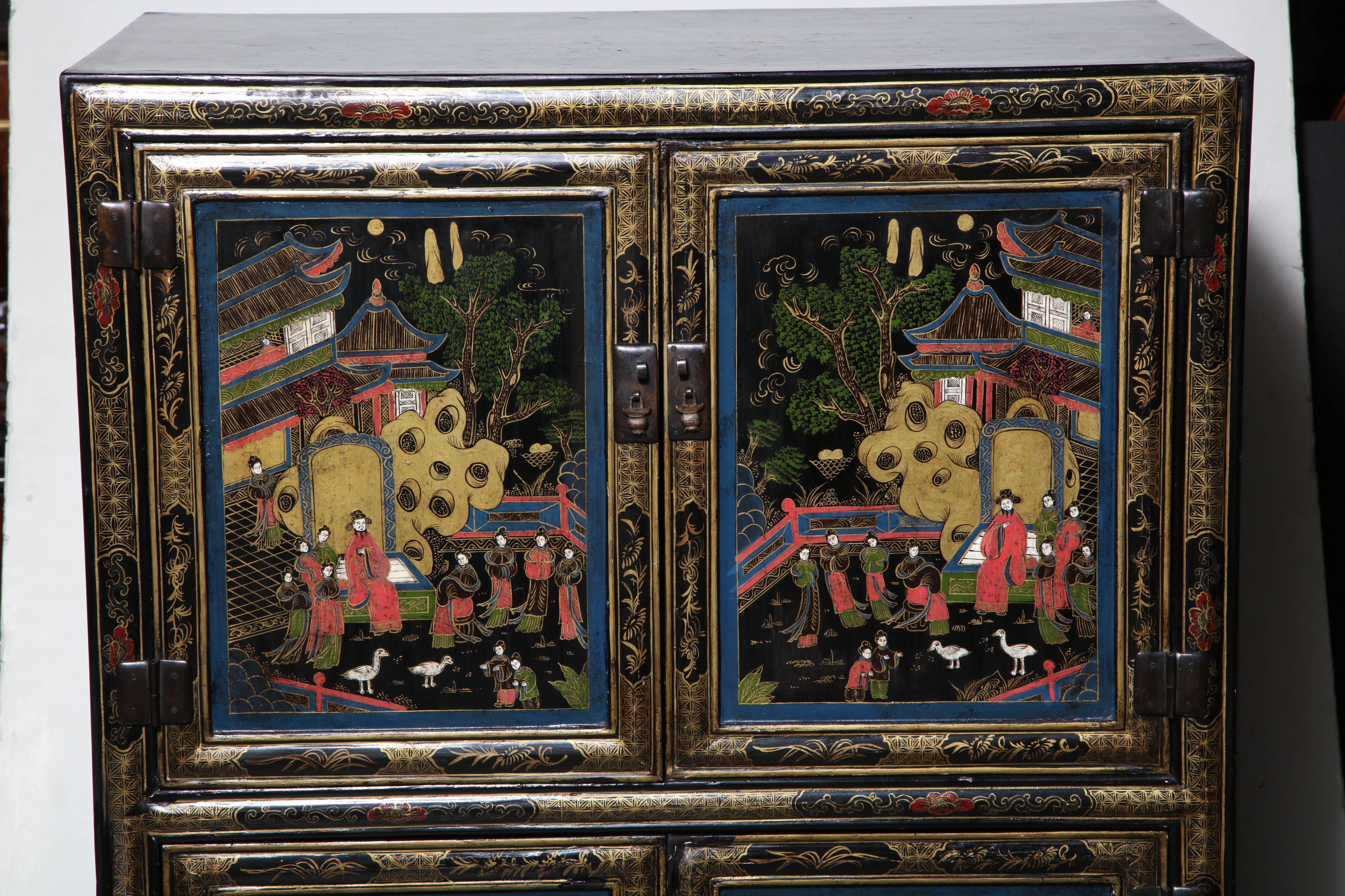 Pair of Chinese black lacquered and decorated four-door cabinets with two drawers.