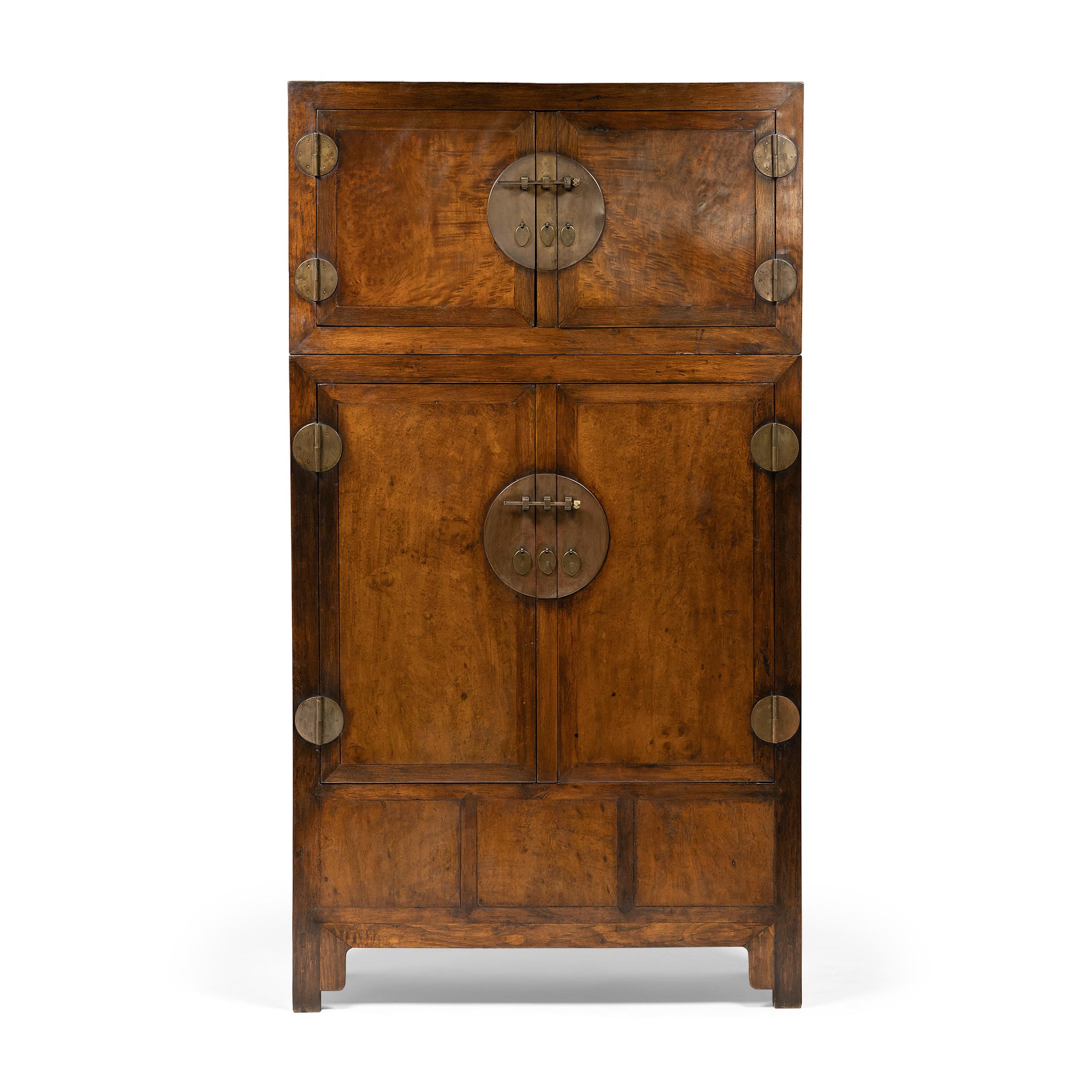 These refined Qing-dynasty compound cabinets command their surroundings with grand scale and fine materials. Constructed of camphor with traditional joinery, the tall cabinets are comprised of two separate, stacked storage compartments. The upper