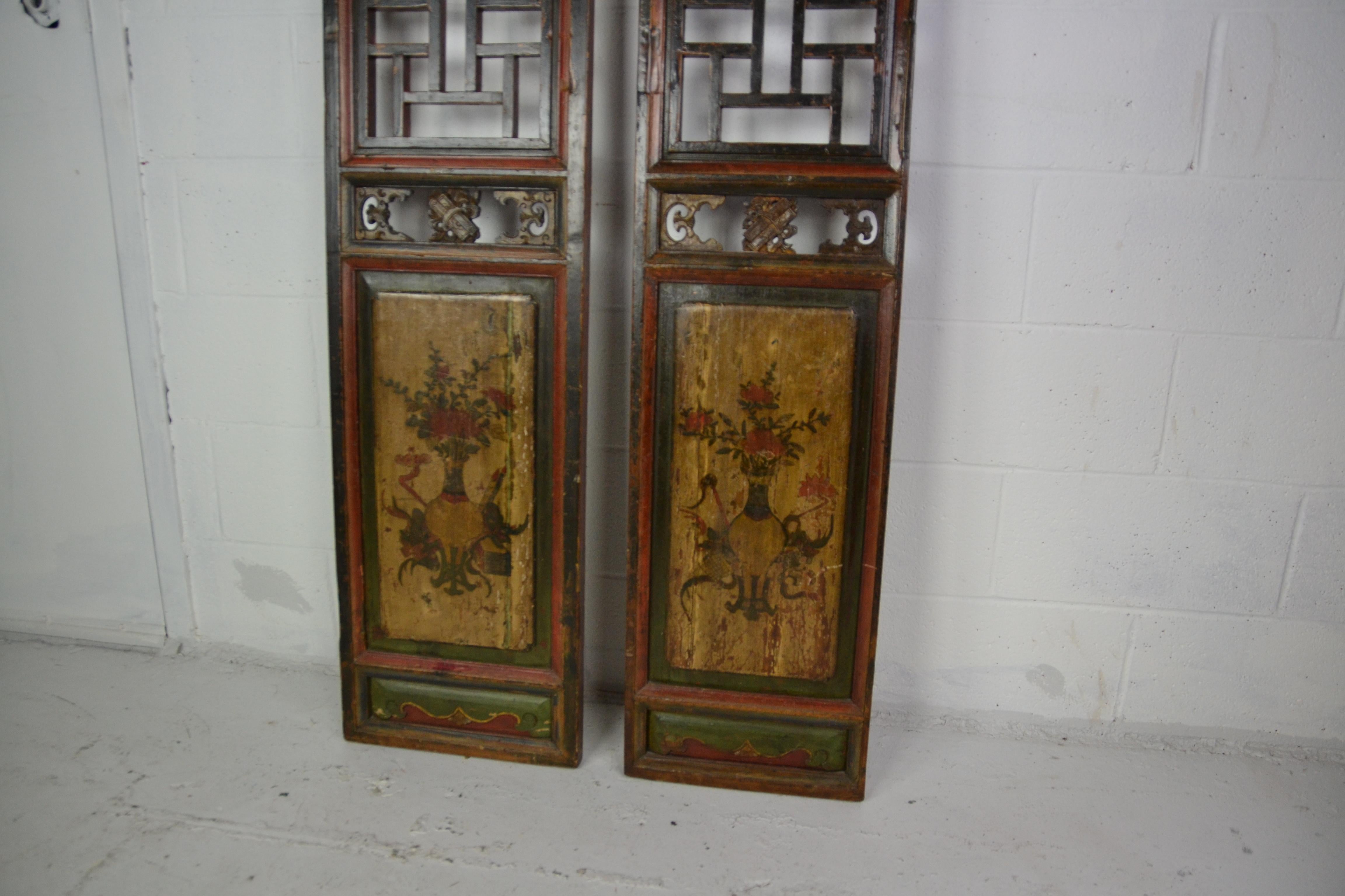 A pair of late 19th century Chinese panels in a red and black ground. Panels hand painted design over faded gold.