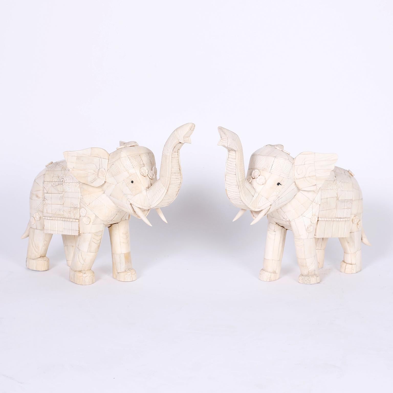 Pair of Chinese elephants crafted in bone over wood decorated with festive saddlery and flowers. Trunks up for good luck.