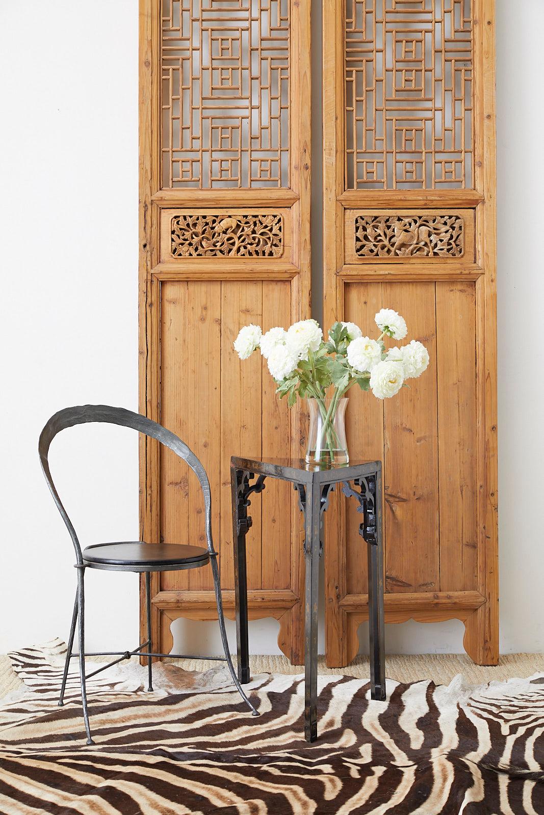 Distinctive pair of Chinese carved doors featuring an open fretwork design lattice panel windows. The thick frames have an old world mortise and tenon joinery. Standing over 9.5 feet tall and 20.5 inches wide. Decorated with foliate motif inserts on