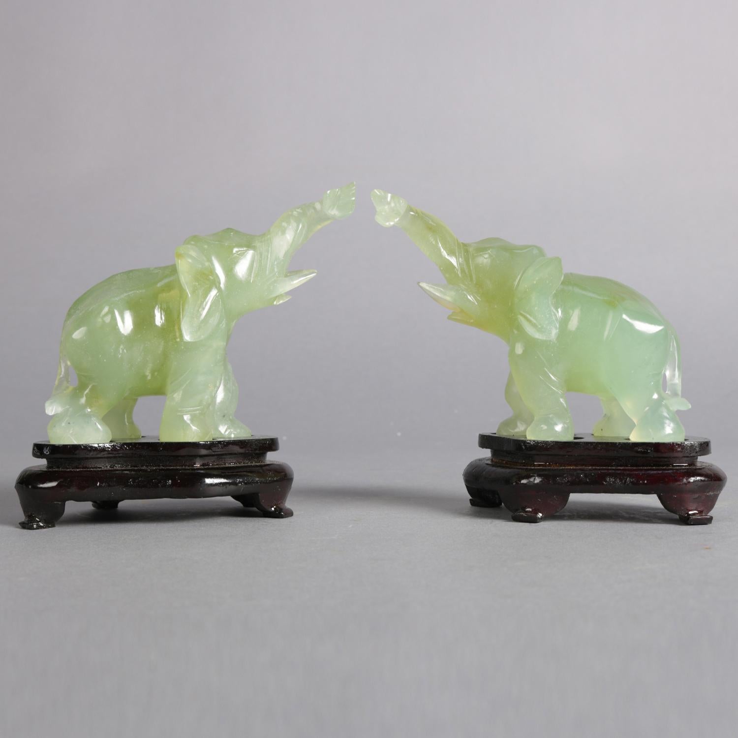 Pair of Asian carved jade elephant sculptures with upswept trunks symbolizing 