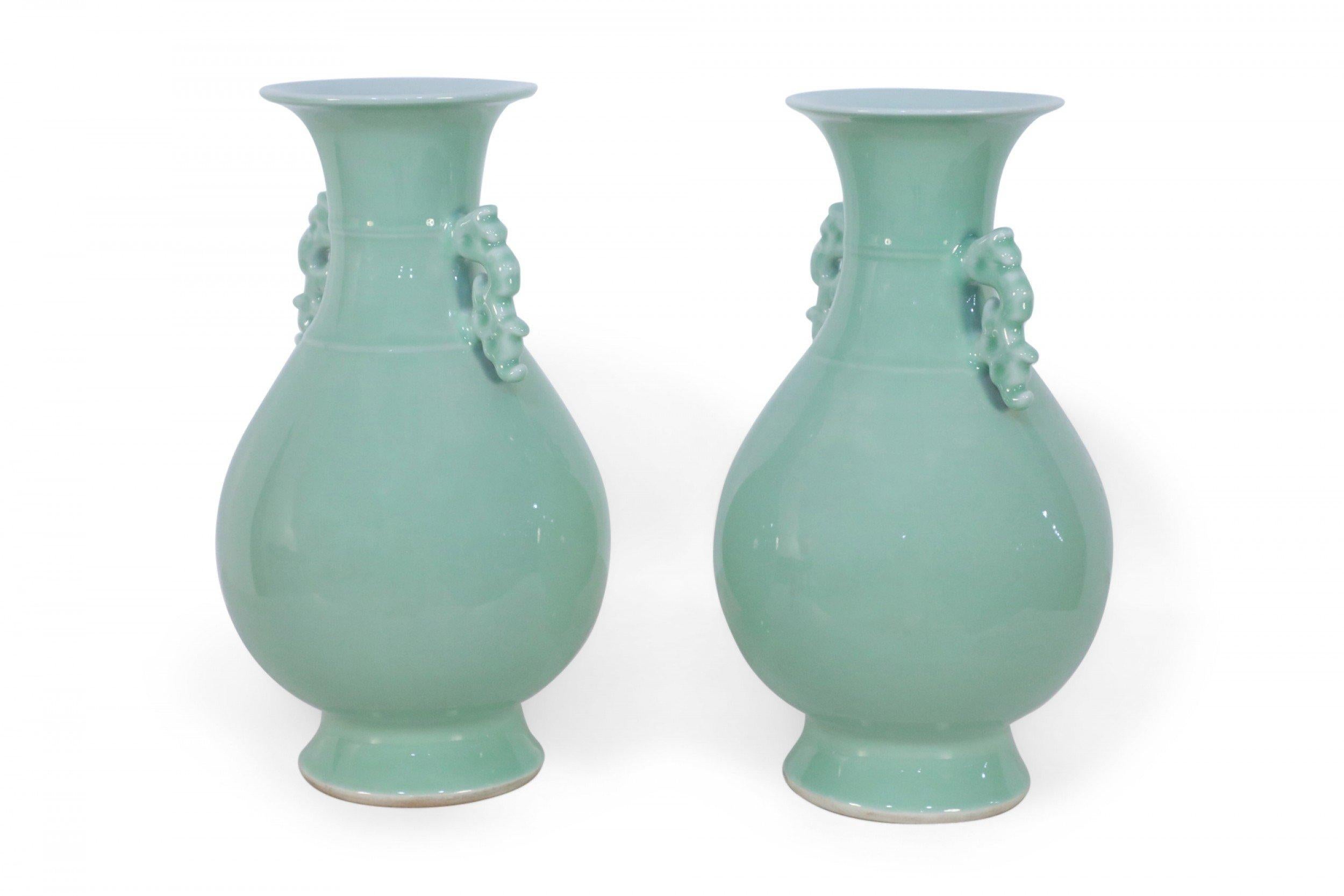 COPPIA di vasi cinesi color celadon con forme a balaustro, accentuate al collo da orecchie a voluta, ciascuno seduto in cima a un piede rotondo  (PREZZO IN COPPIA).