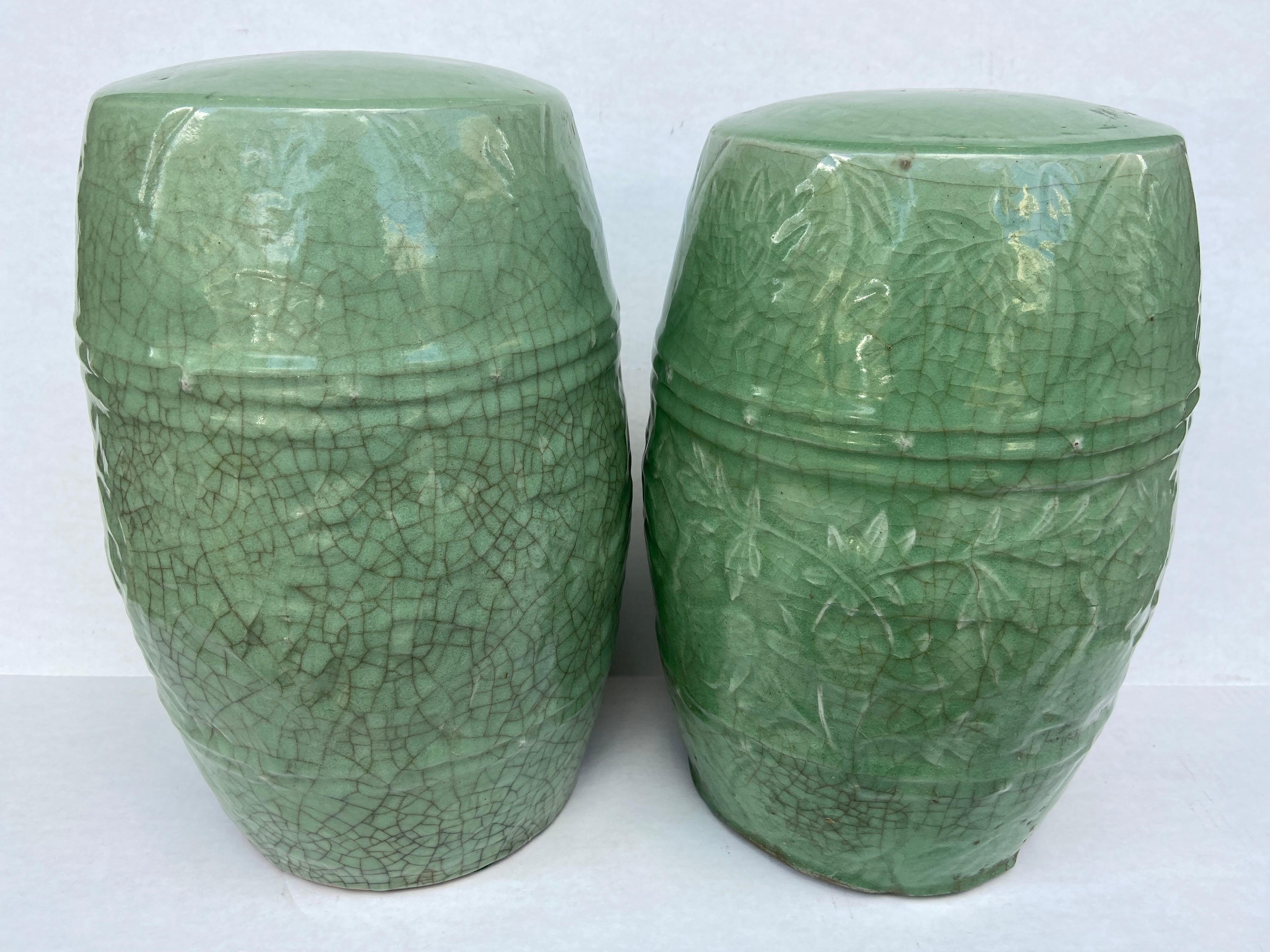 Pair of Chinese Celadon green Ceramic barrel form garden seats. Raised design seat and all over ornamentation with a crackle celadon glaze thru out. A fired semi-opaque glaze is designed to create a crackle pattern during the firing process to