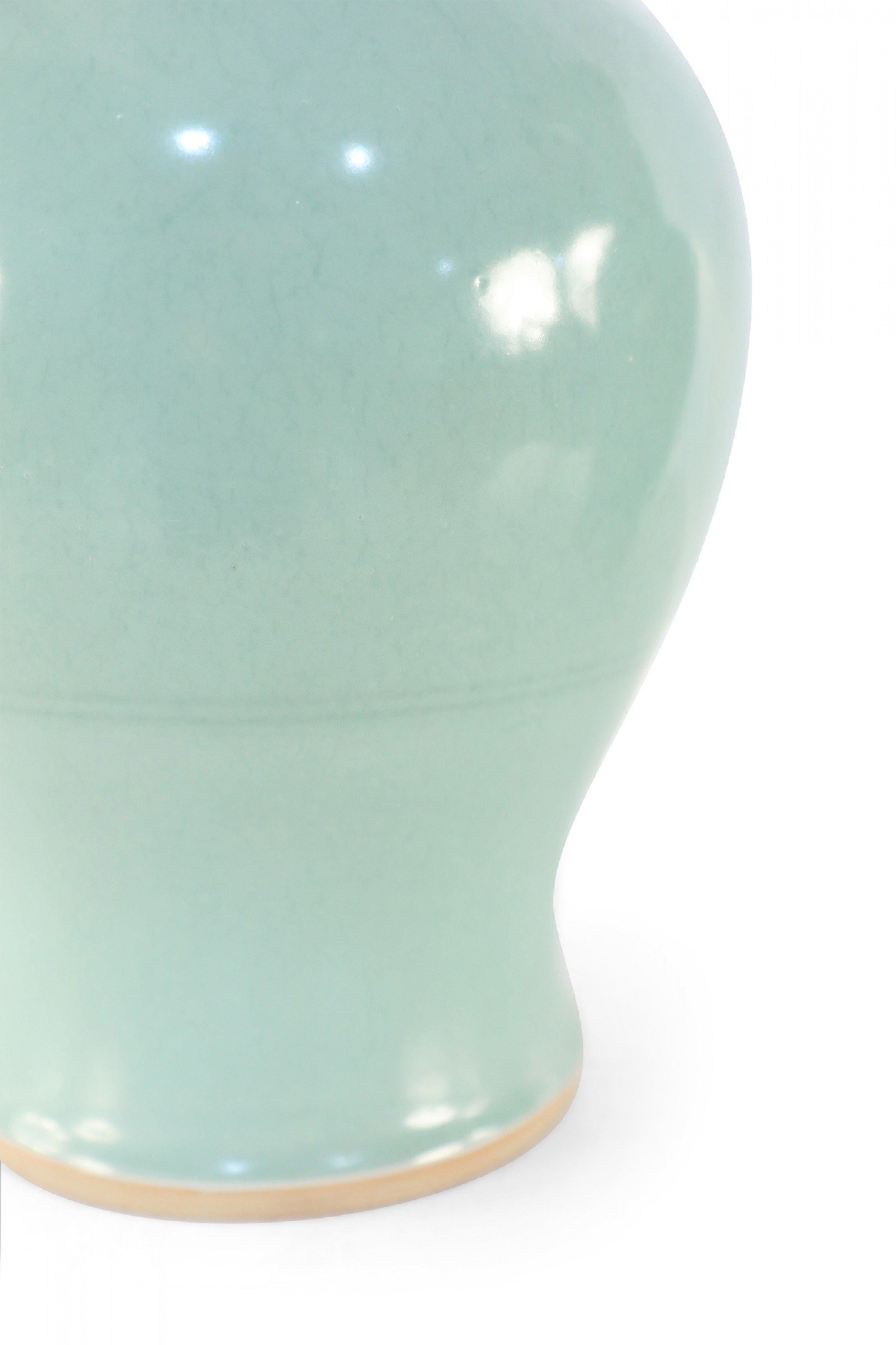 PAR de urnas chinas de porcelana celadón con continuos motivos arremolinados en relieve que fluyen por los esbeltos cuellos estriados. (PRECIO POR PAR).

Estado: Bueno; Desgaste acorde con la edad y el uso