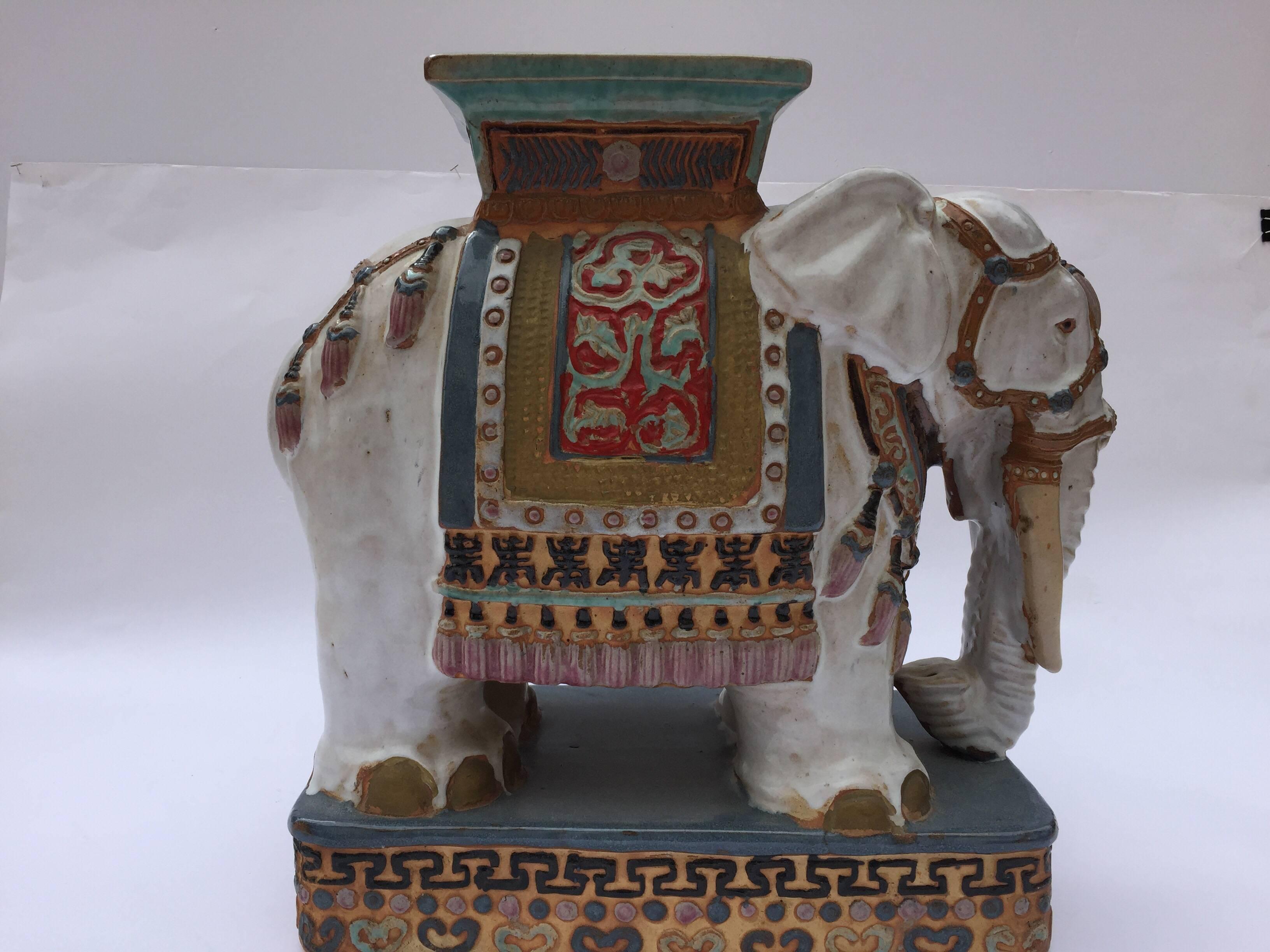 Large pair of vintage midcentury Asian Chinese white elephant outdoor garden stools or side drink tables.
Hand-painted ceramic elephant garden stools richly decorated with earth-tone glazes and symbols of longevity in aqua, ivory, red and gold