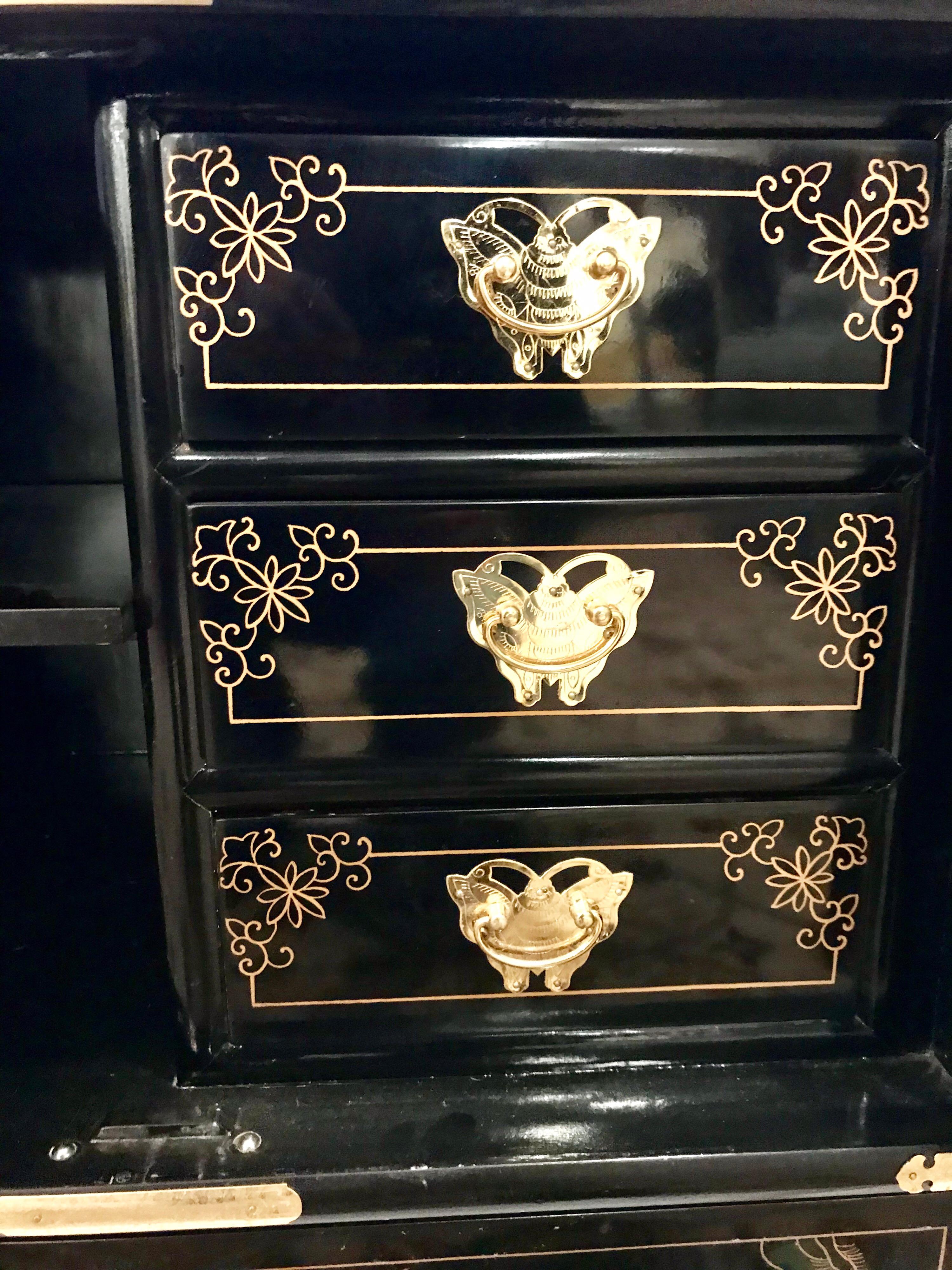 Pair of black lacquer chinoiserie nightstands with matching mirrors that can be hung. Hand painted with flowers and birds. Features ornate incised brass hardware. Doors open to storage compartment and three drawers with butterfly pulls. Mirrors