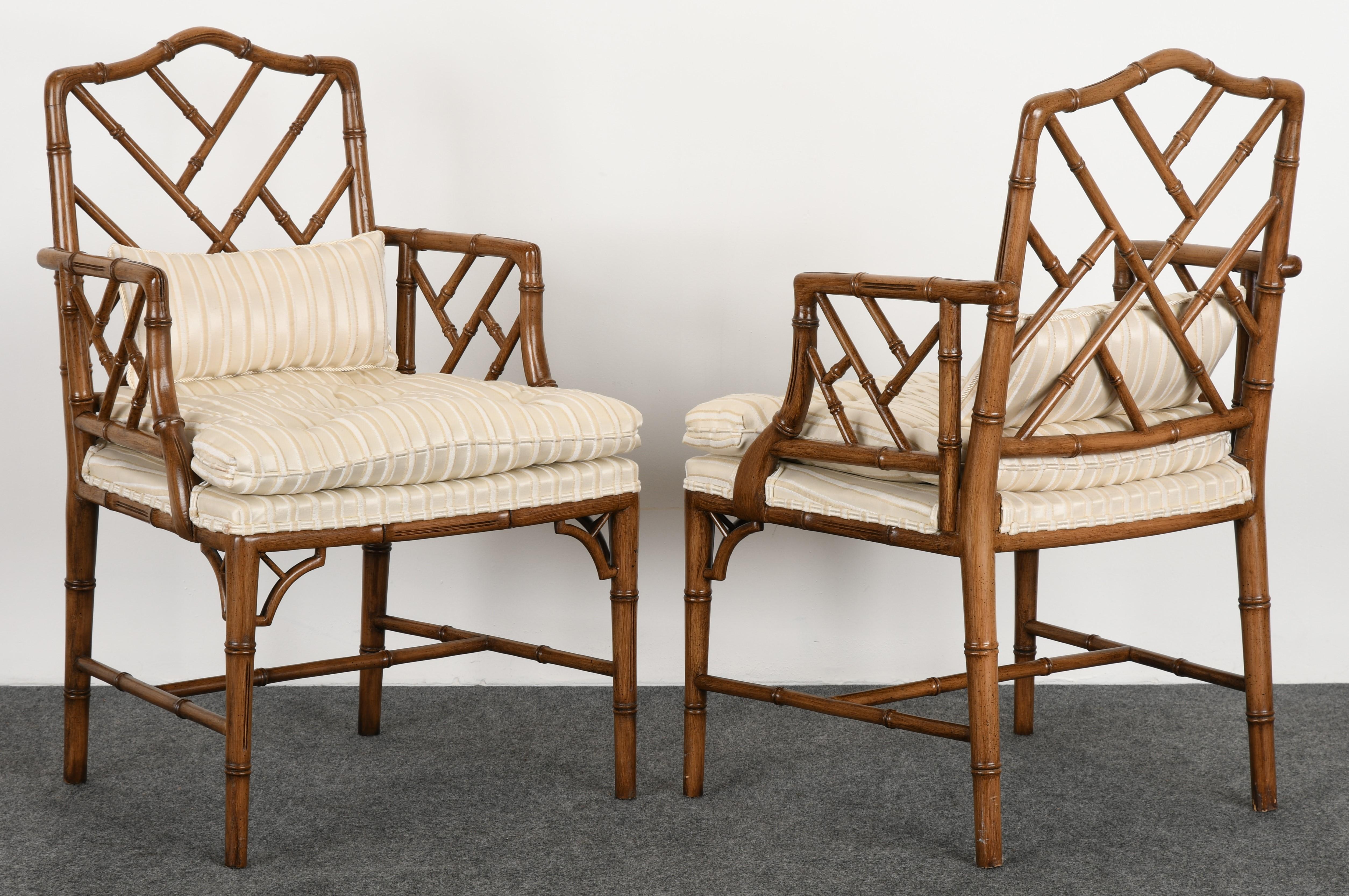 A pair of decorative stained maple faux bamboo armchairs. The chairs have a Classic trellis back and arms, with Asian motif and elegant tapered legs. The chairs are structurally sound. New fabric recommended.

Dimensions: 36.75