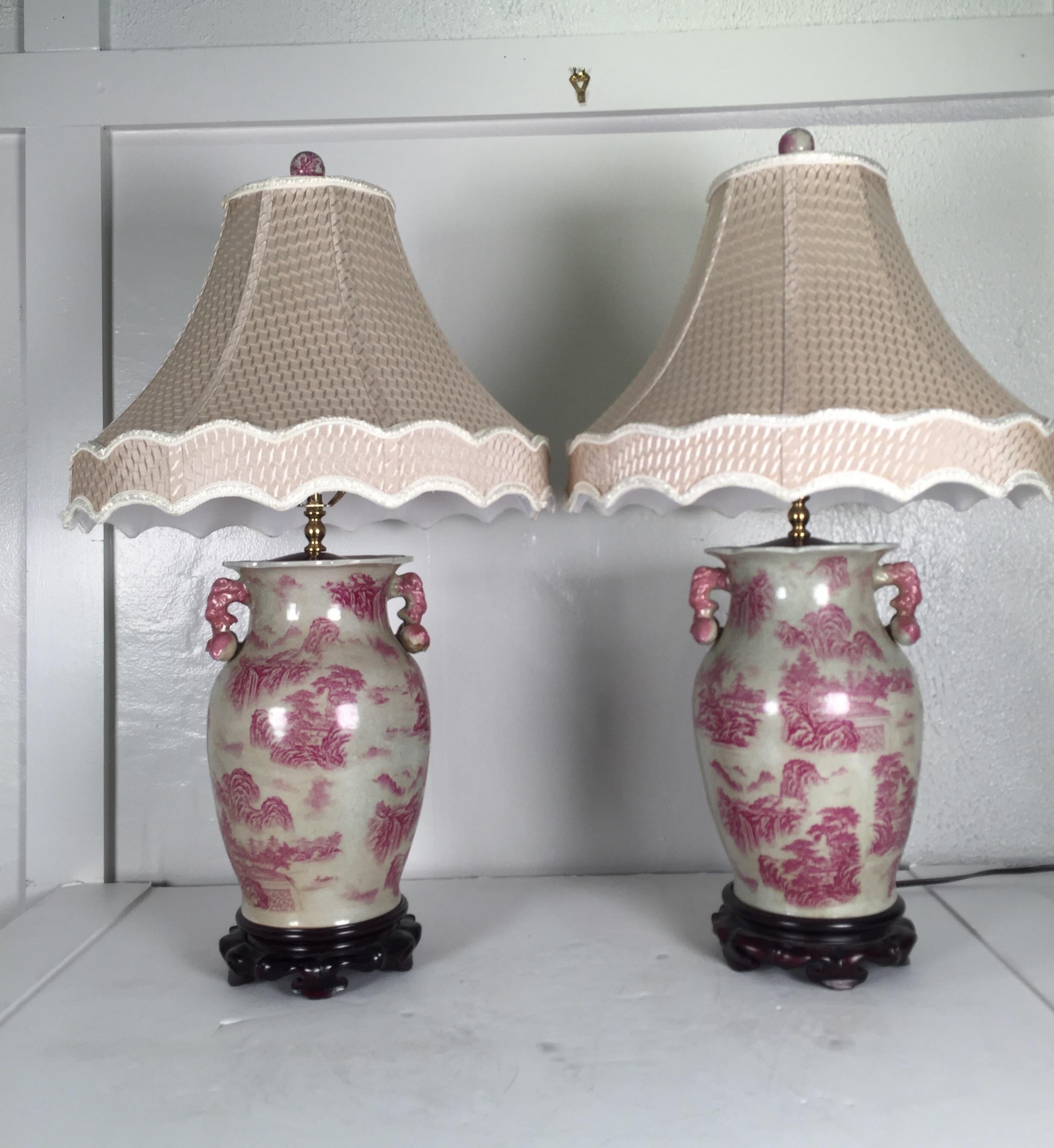 Elegant pair of porcelain chinoiserie table lamps with mahogany bases, both with scalloped lamp shades.