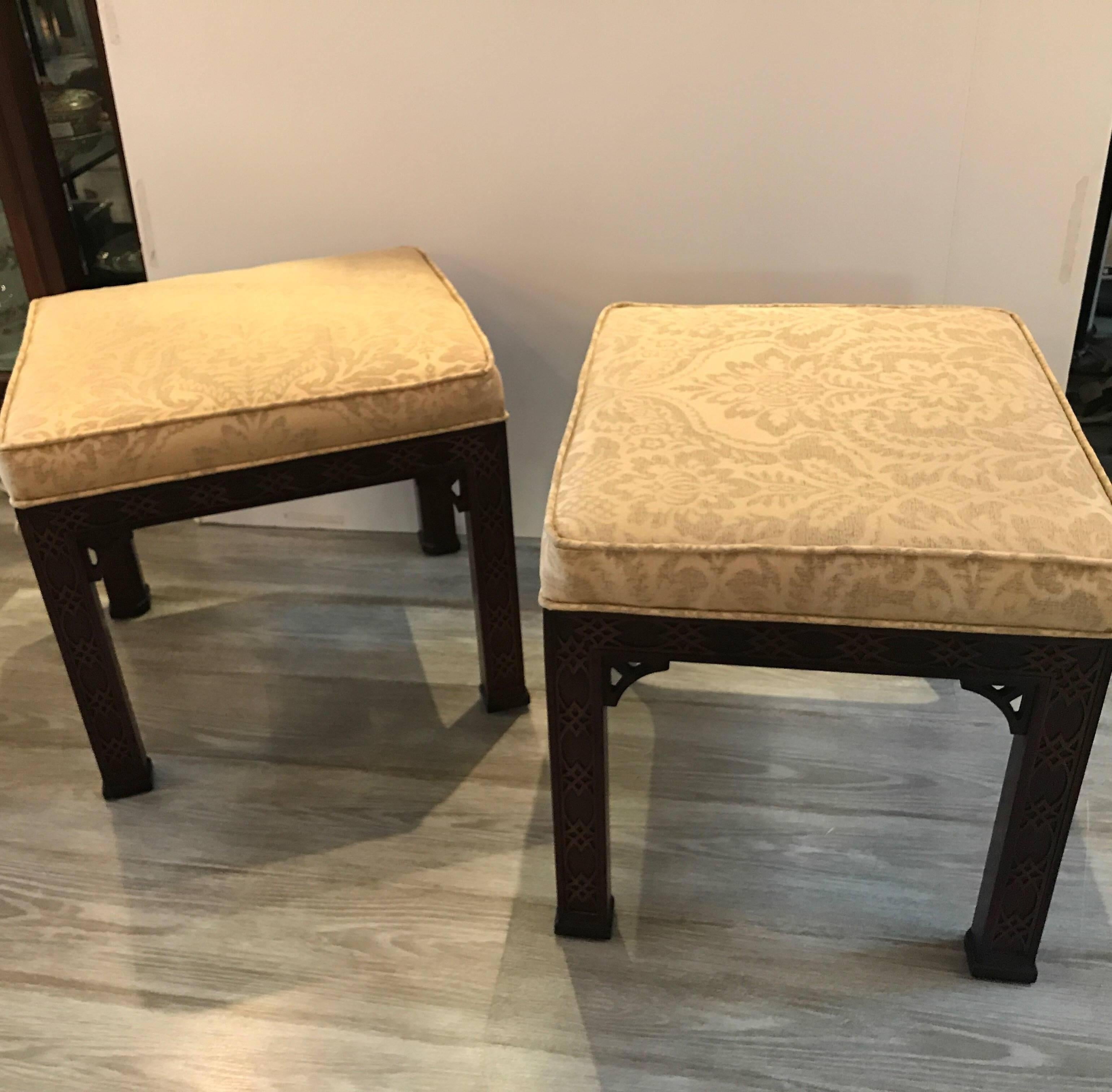 A pair of mahogany benches made by the premier American furniture maker, Kindel. Of Classic form with new neutral damask upholstery. . The mahogany bases with a lattice detail.