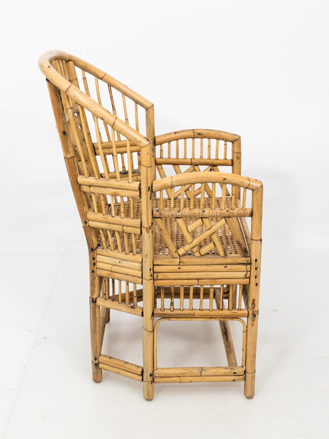 Pair of bamboo and cane Chinese Chippendale style armchairs inspired by armchairs from Brighton Pavilion, circa 20th century. Please note of minor repair to the underside of the chair along with wear consistent to age.
  
